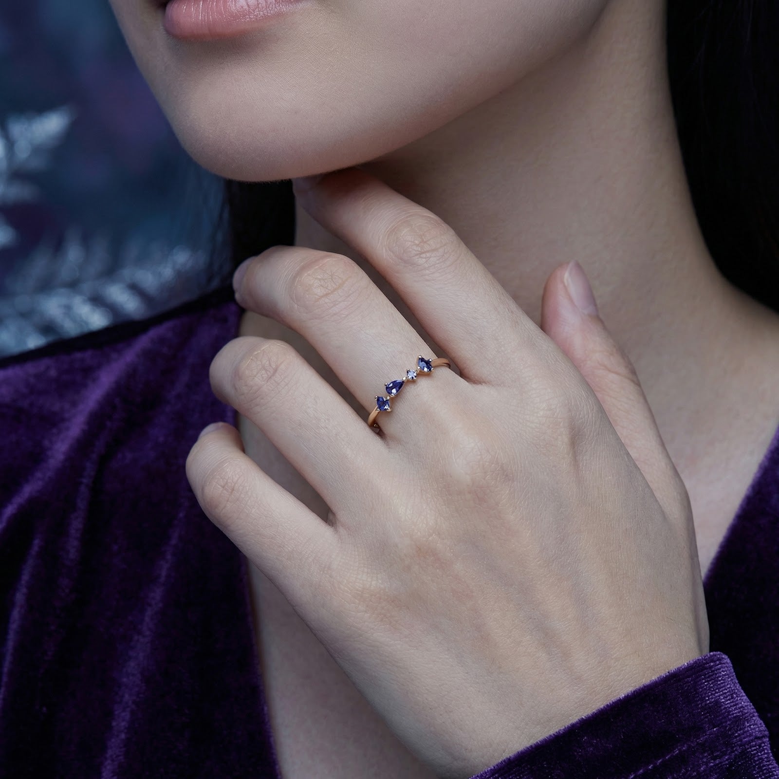 Model wearing the 18K gold vermeil Nerisara cascade ring with blue simulated tanzanite stones on her finger.