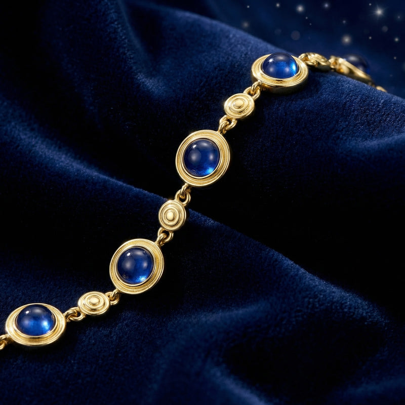 Macro view of round cabochon simulated sapphires in 18K gold vermeil bezel settings.