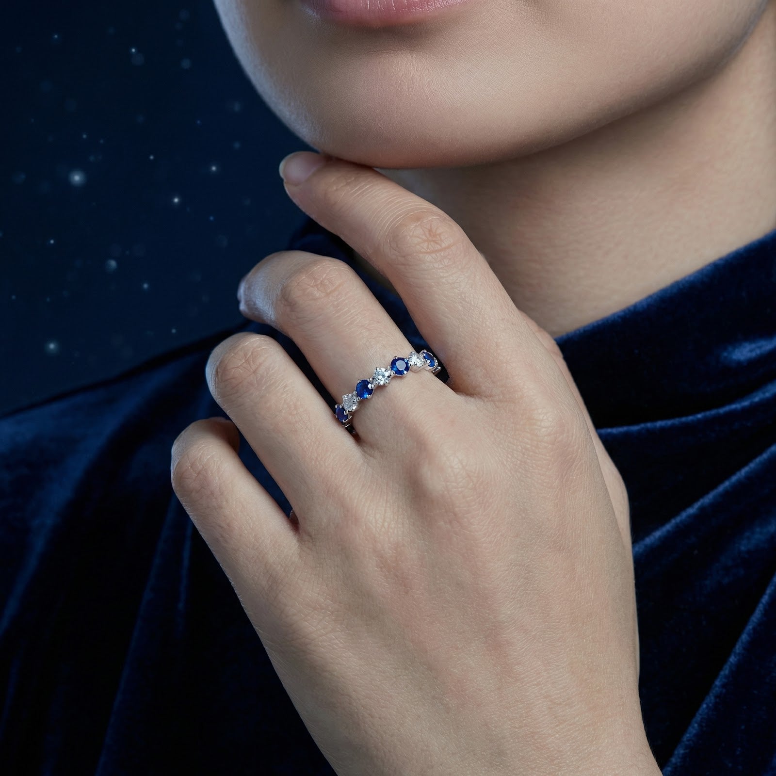 Thalissara sterling silver row ring with alternating blue simulated sapphires and clear stones worn by a model.