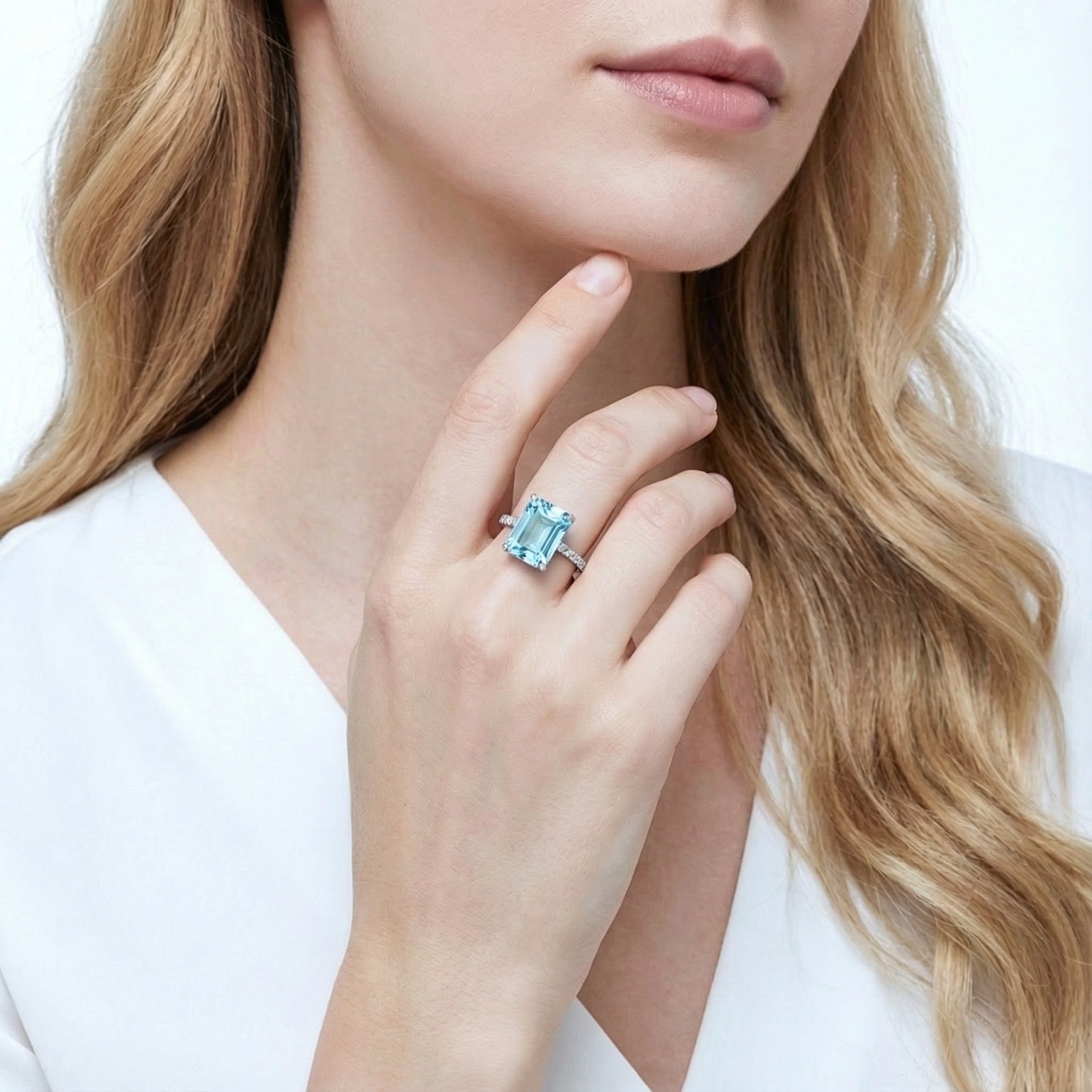 Model wearing the radiant-cut simulated aquamarine sterling silver ring against a white blouse.