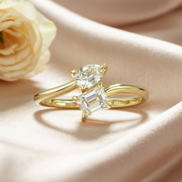 The Melora Muse Toi et Moi solid gold ring with emerald and pear cut moissanite stones.