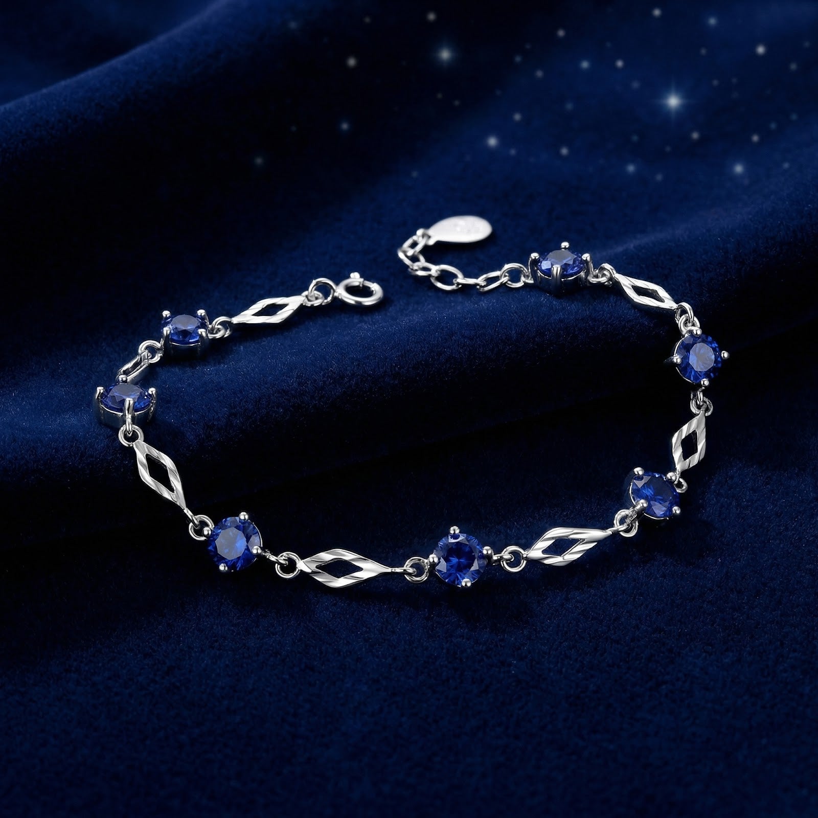 Nerienne station bracelet in S925 sterling silver with round blue simulated sapphires on blue velvet.