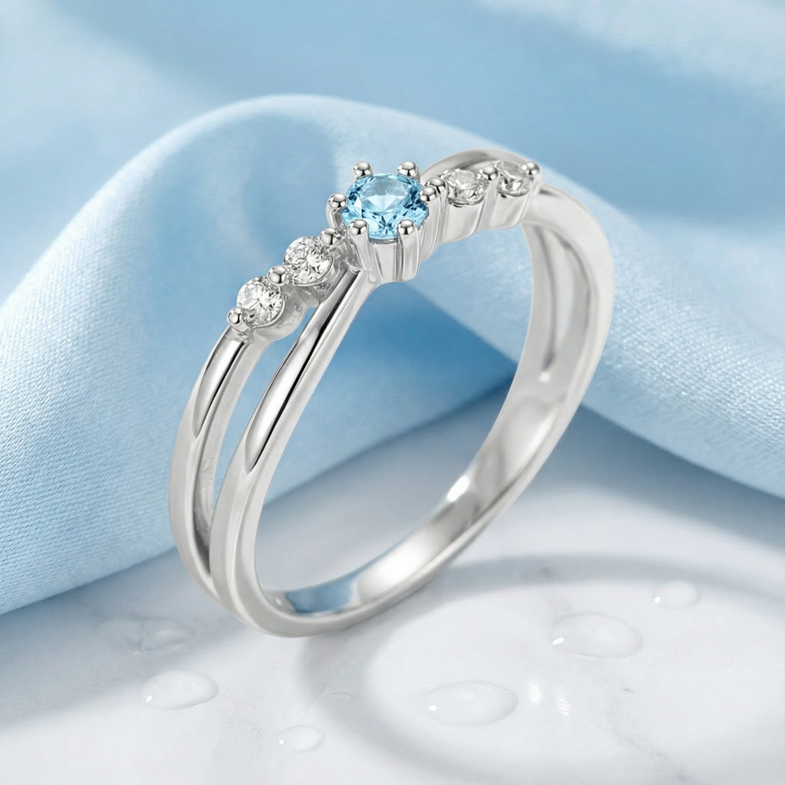 Angled view of the Sylphide silver ring featuring a round light blue simulated aquamarine and accent stones.