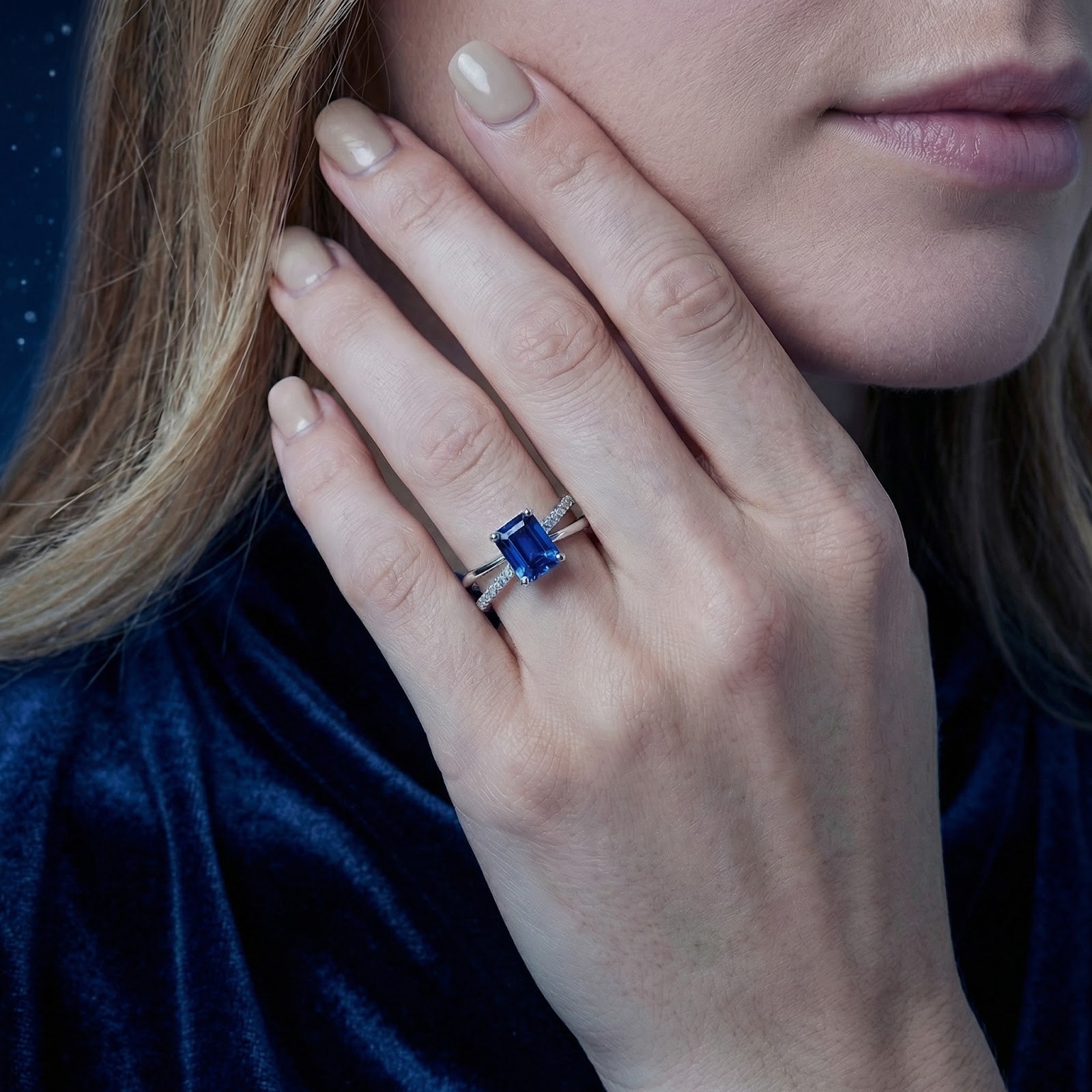 Woman wearing the emerald-cut simulated sapphire crossover ring in S925 sterling silver on her ring finger.