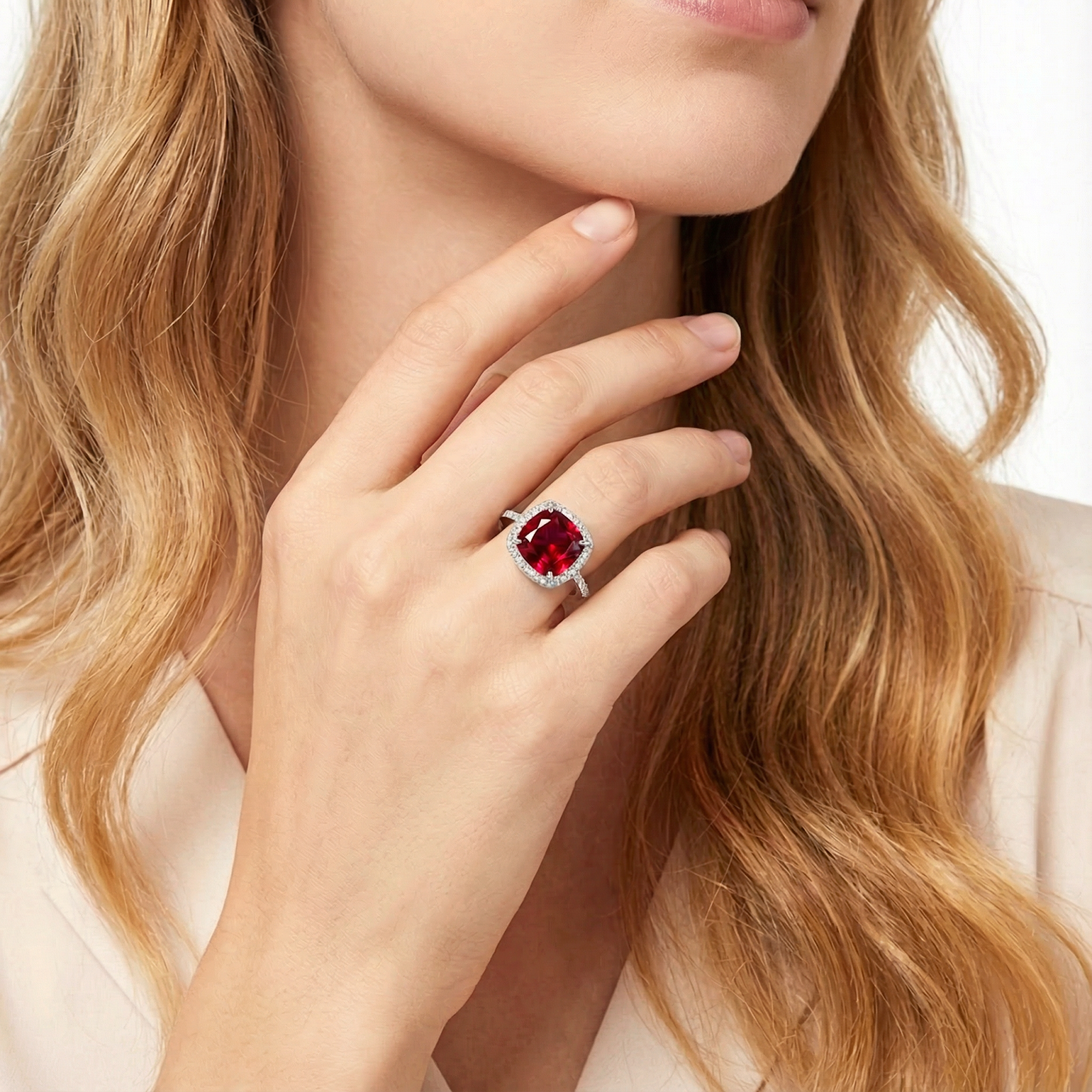 Lifestyle view of a model wearing the cushion-cut simulated ruby halo ring in S925 sterling silver.