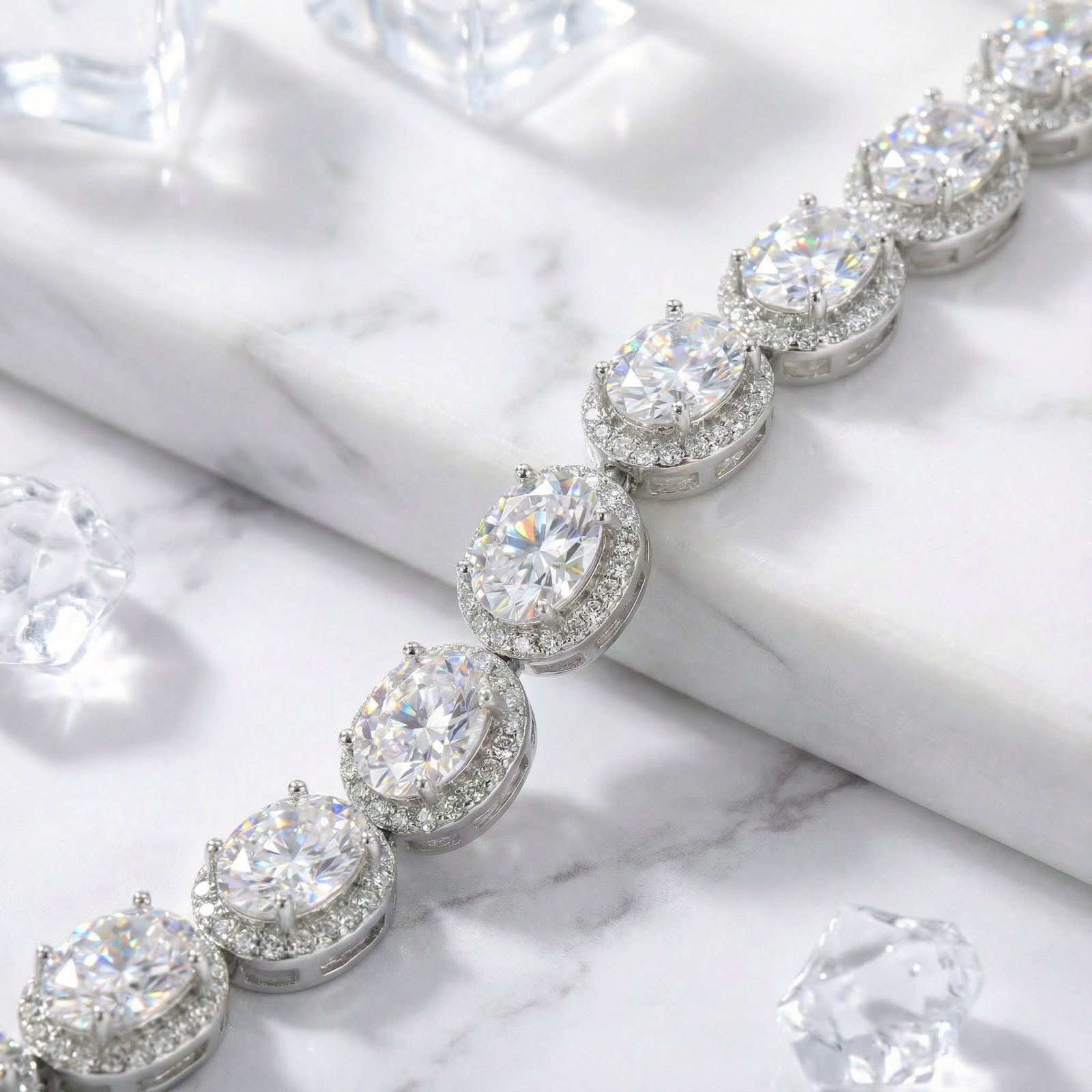 Close-up of oval-cut 5A zirconia stones in protective halo settings on a sterling silver bracelet.