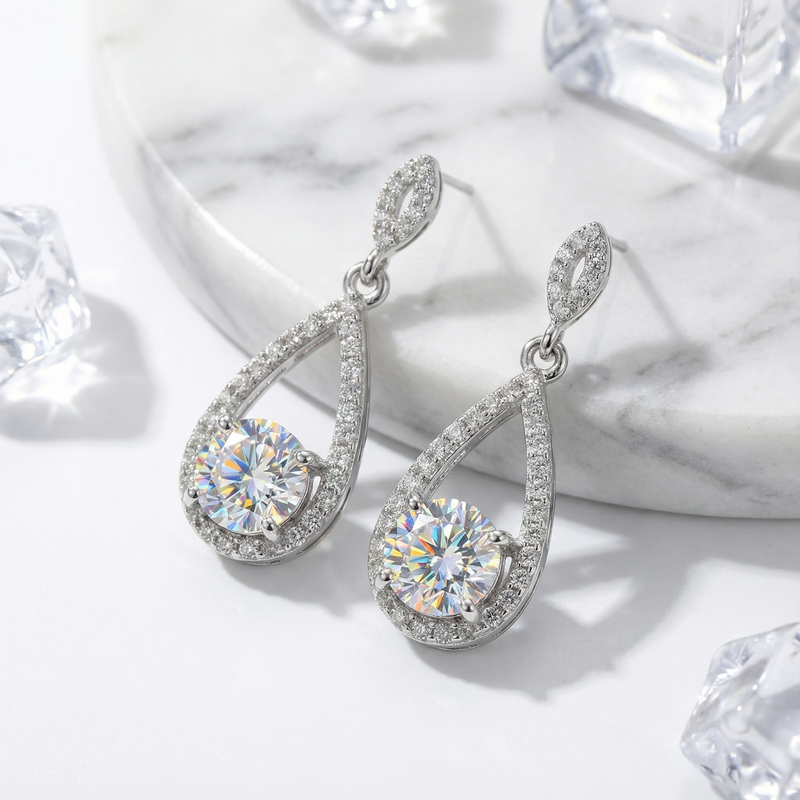 Close-up of sterling silver teardrop earrings featuring brilliant round-cut zirconia and pavé stone settings.