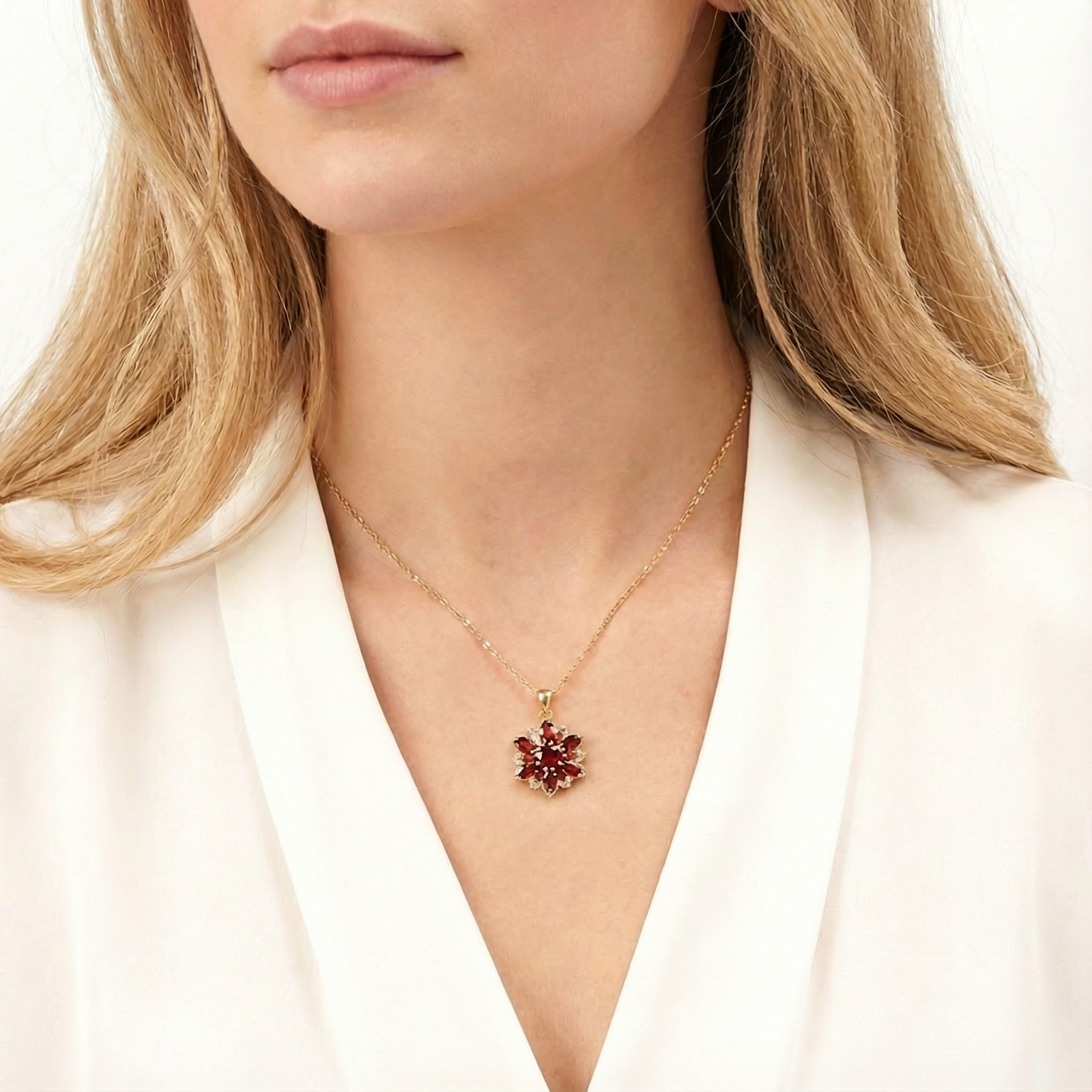 Model wearing the gold finished stainless steel January birthstone necklace with a red garnet pendant.