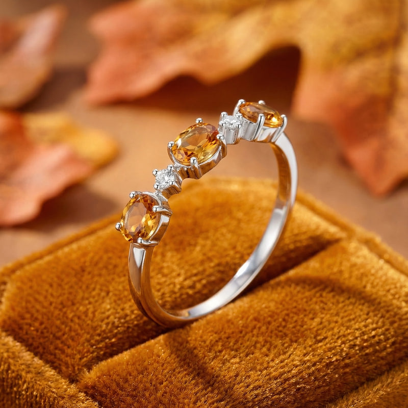 Angled close-up of the Evalise sterling silver bypass ring showing the oval simulated topaz stones and prong setting.