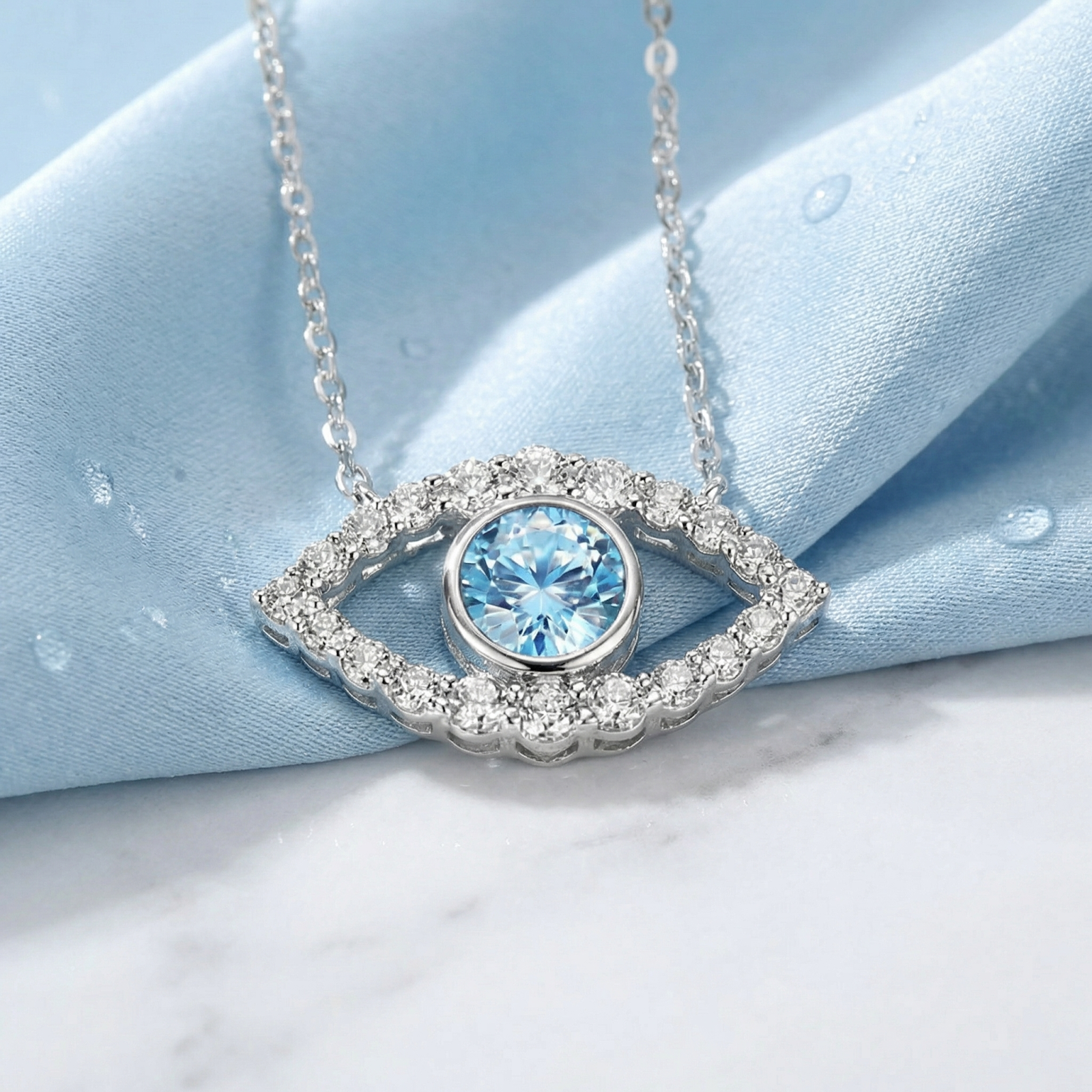 Close-up of the Elara Eye pendant in sterling silver with a round cut simulated aquamarine and brilliant accents.