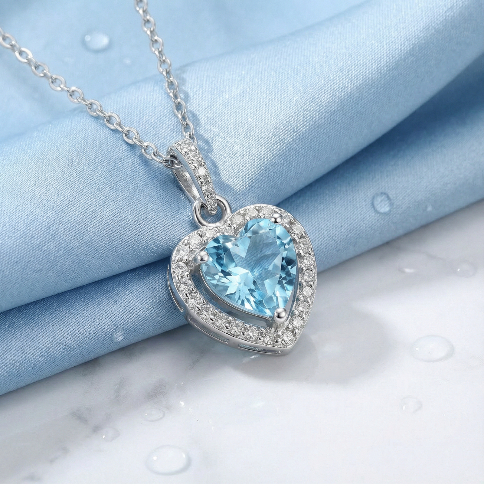 Heart cut simulated aquamarine necklace in sterling silver on a blue silk lifestyle background.