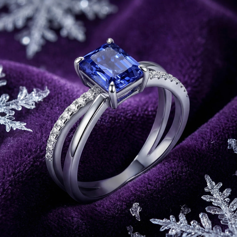 Angled view of the Aurelline radiant-cut simulated tanzanite silver ring showing the crossover band.