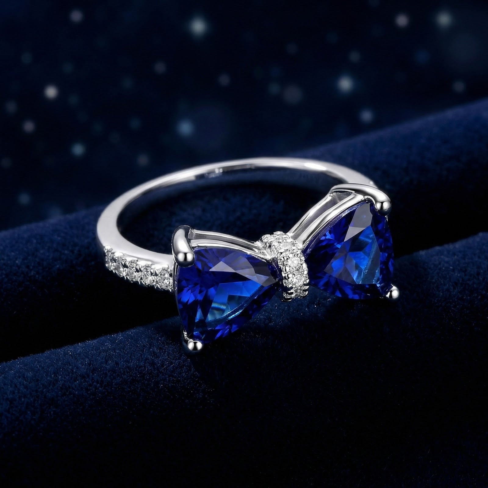 Front view of the S925 sterling silver Marcelle bow ring with two trillion-cut blue simulated sapphires.