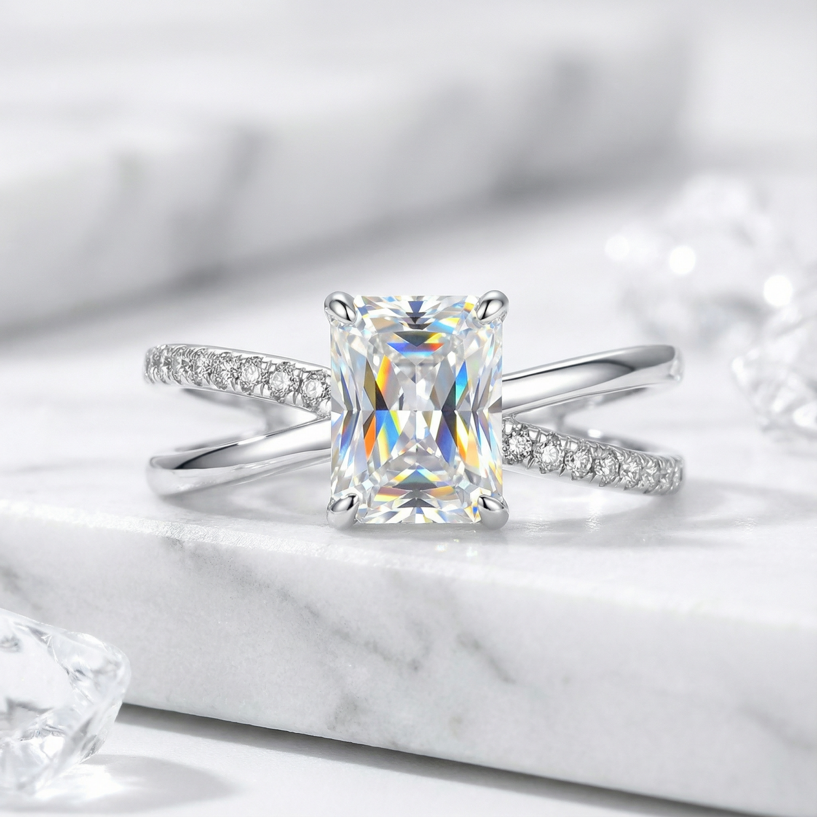 Radiant cut simulated diamond ring in S925 sterling silver with a pavé bypass band on a marble surface.
