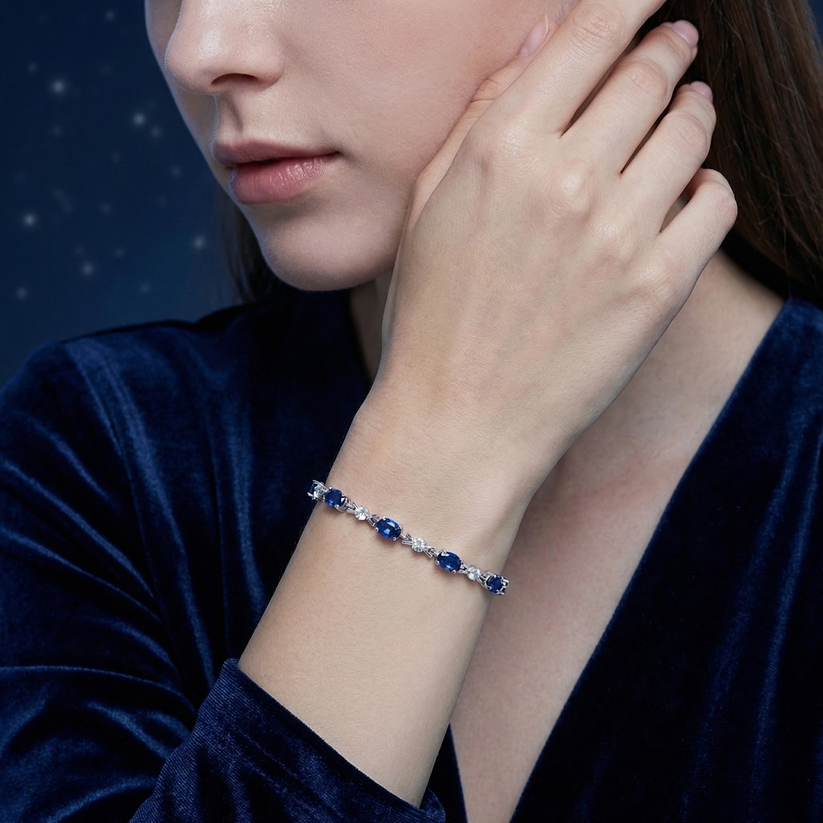 Woman wearing the Marisara Oval sterling silver bracelet featuring deep blue simulated sapphires.