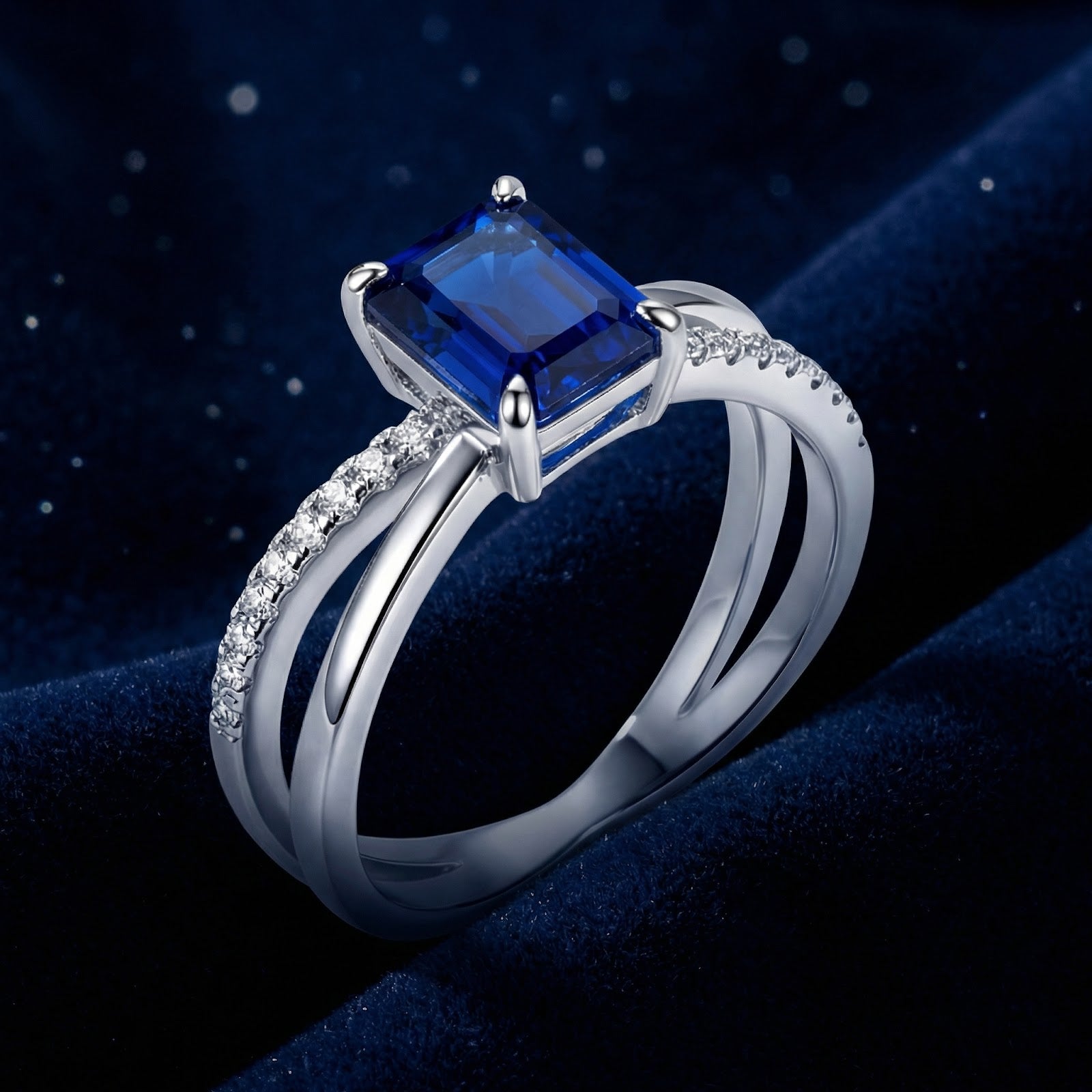 Side profile of the S925 sterling silver crossover ring with an emerald-cut simulated sapphire and pavé accents.