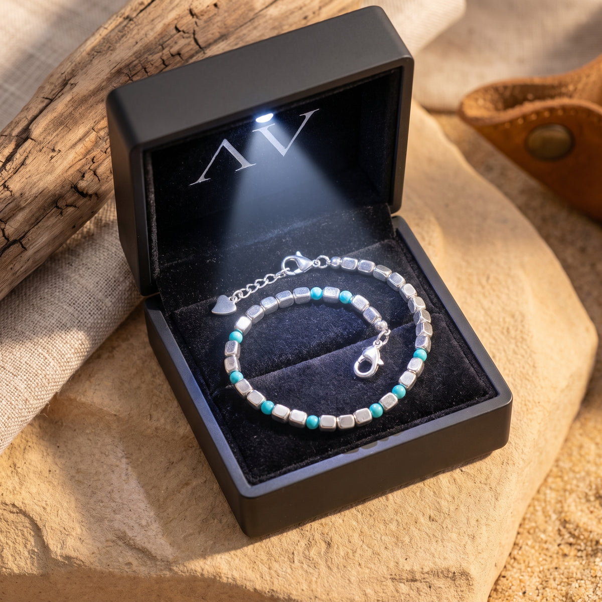 Silver and turquoise bead bracelet presented in a black LED-lit jewelry box.