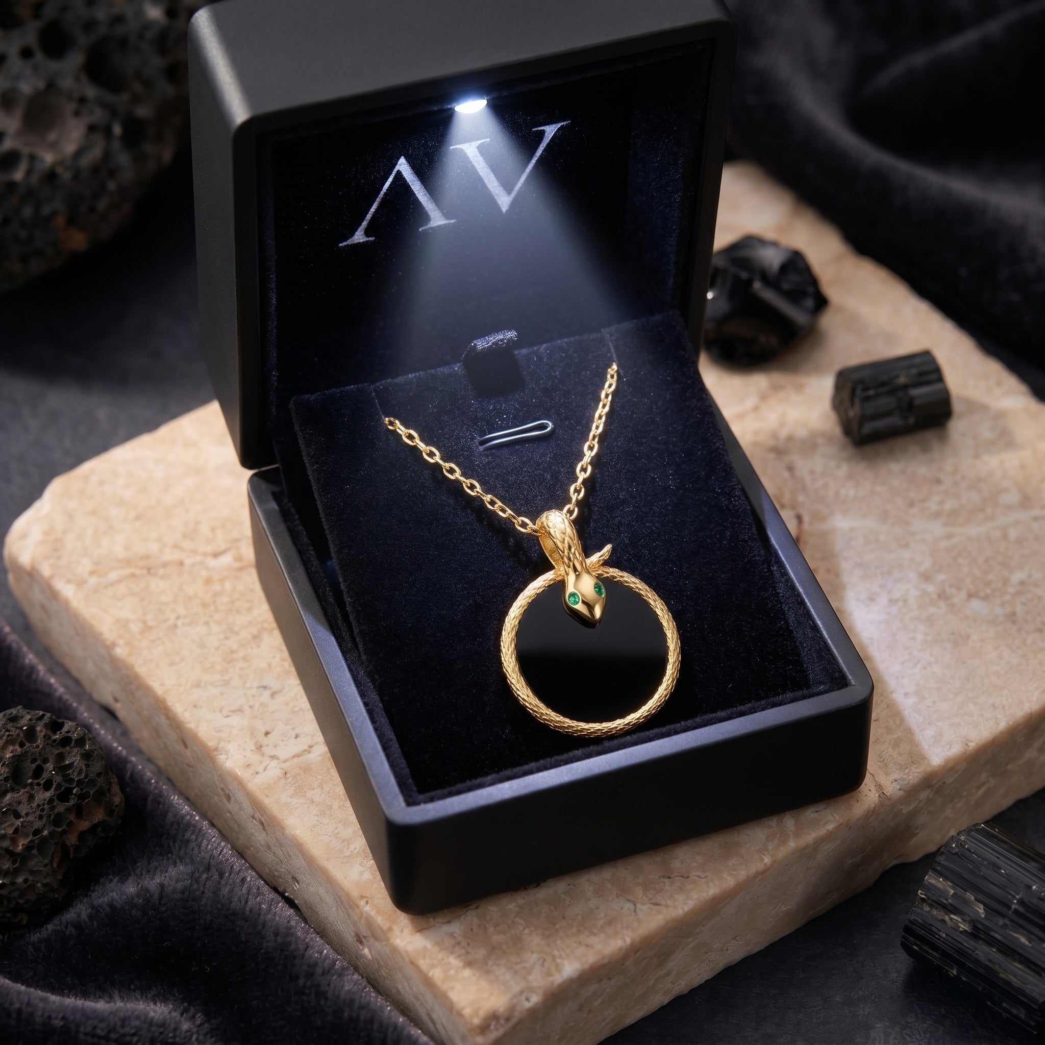 Gold snake onyx necklace inside a black LED-lit jewelry presentation box.