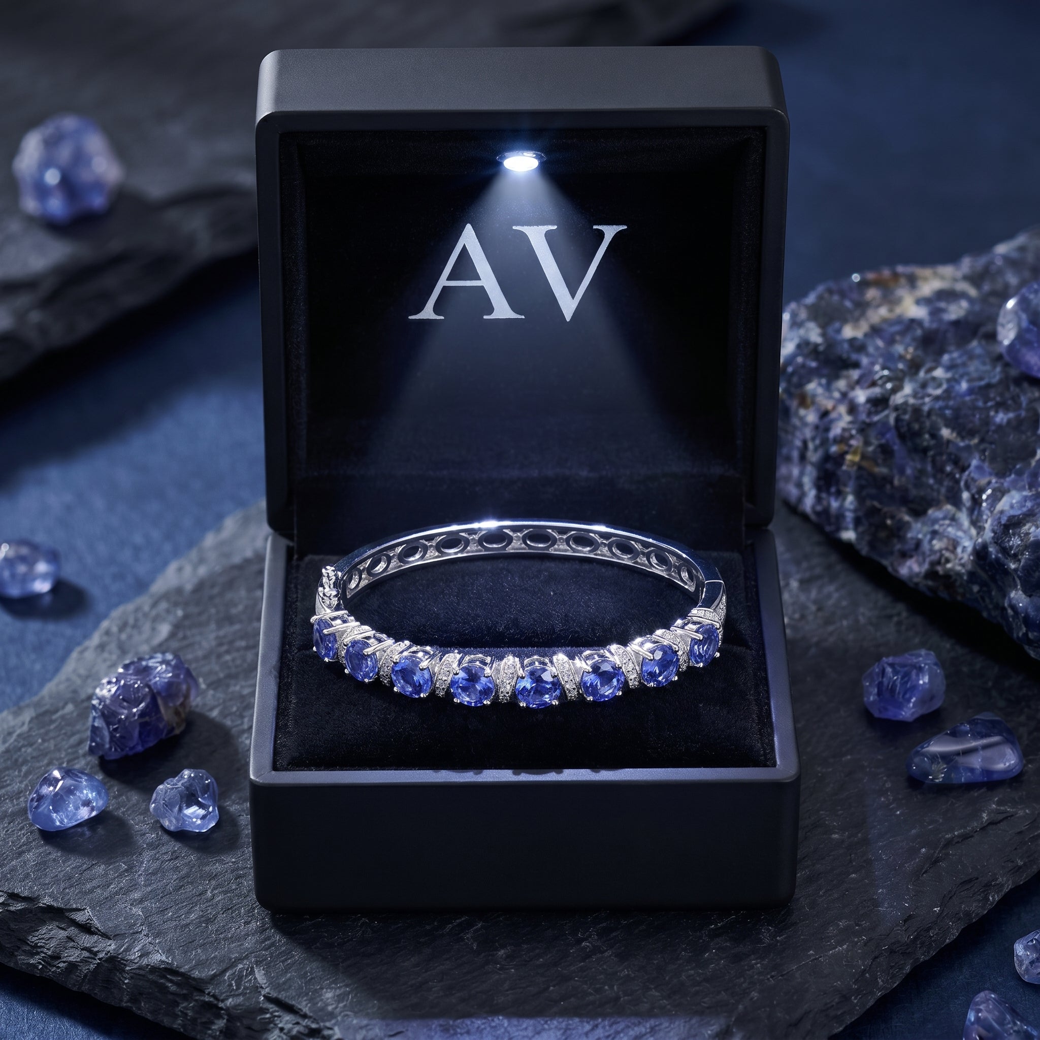 White gold pear-cut tanzanite bracelet presented in a lighted black AV jewelry gift box.