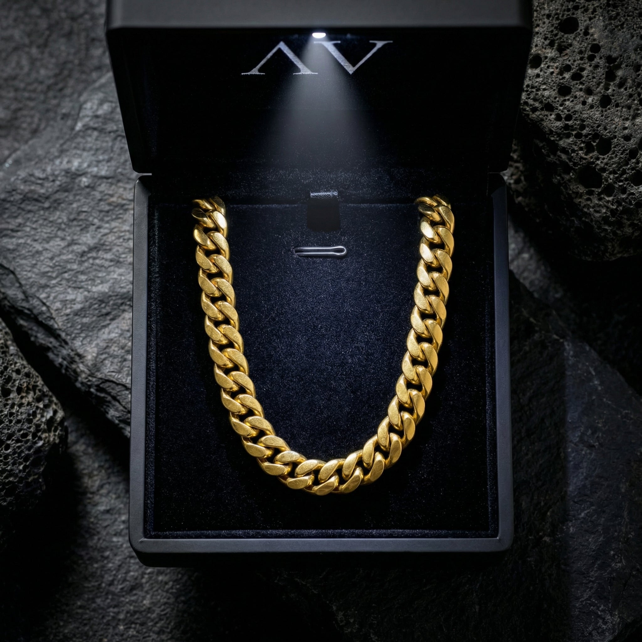 Gold-tone stainless steel Cuban link chain presented in a black illuminated jewelry gift box.