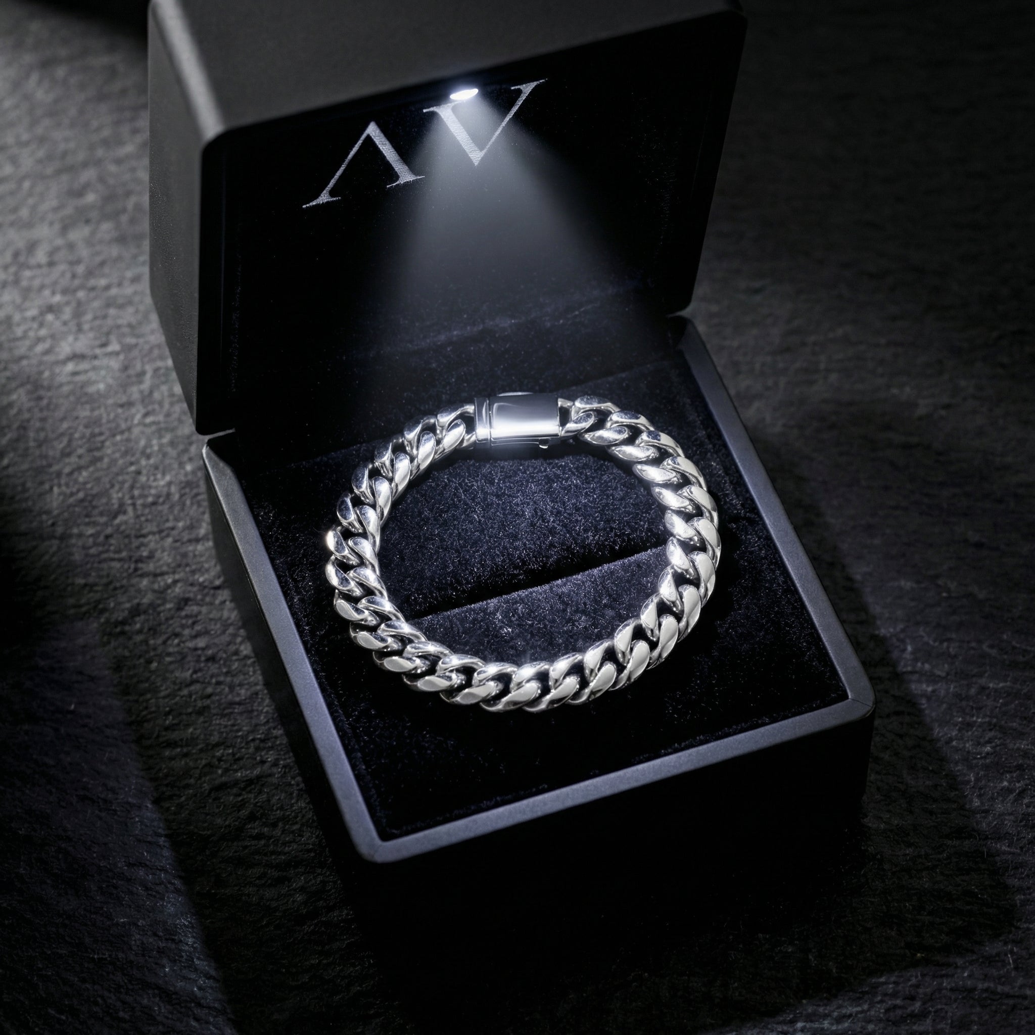 Silver stainless steel Cuban link bracelet showcased in a black illuminated jewelry gift box.