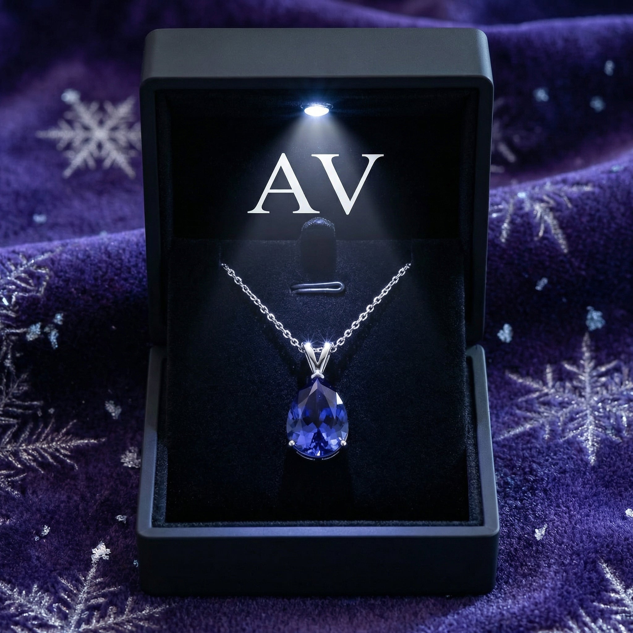Pear-cut blue moissanite silver necklace inside a lighted black AV branded jewelry gift box.