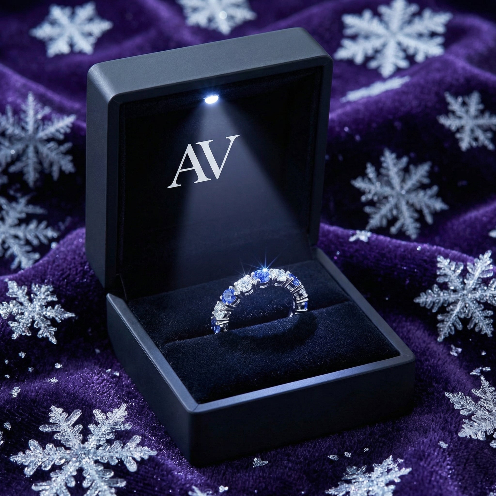 S925 sterling silver simulated tanzanite ring inside a black LED-lit AV presentation box with snowflakes.