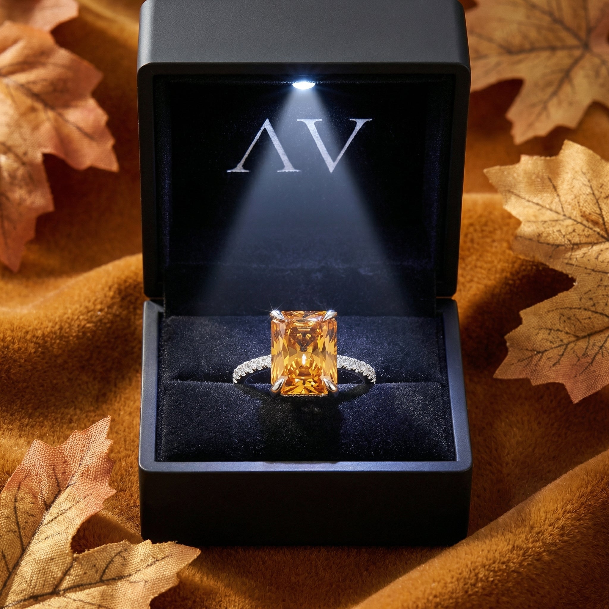 Radiant cut simulated topaz sterling silver ring inside a black LED-lighted presentation box.