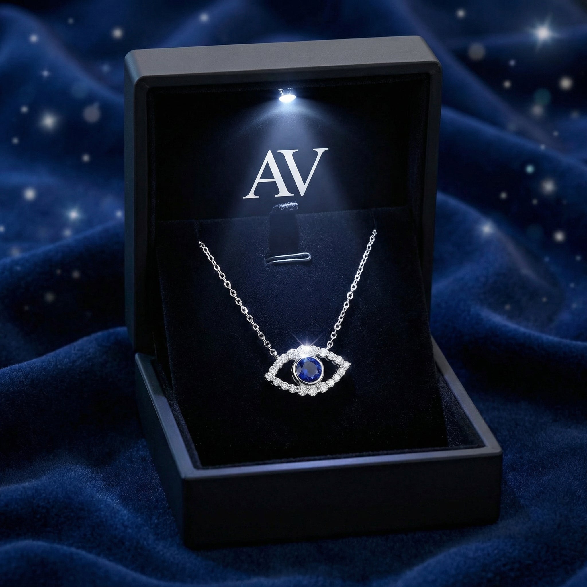 Sterling silver Syrenne Eye necklace with a blue sapphire in a lighted black jewelry presentation box.