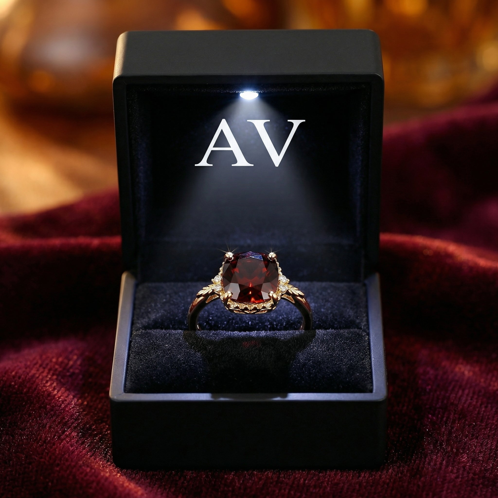 Valerine cushion cut simulated garnet ring in 18K gold vermeil presented in a lighted black jewelry box.