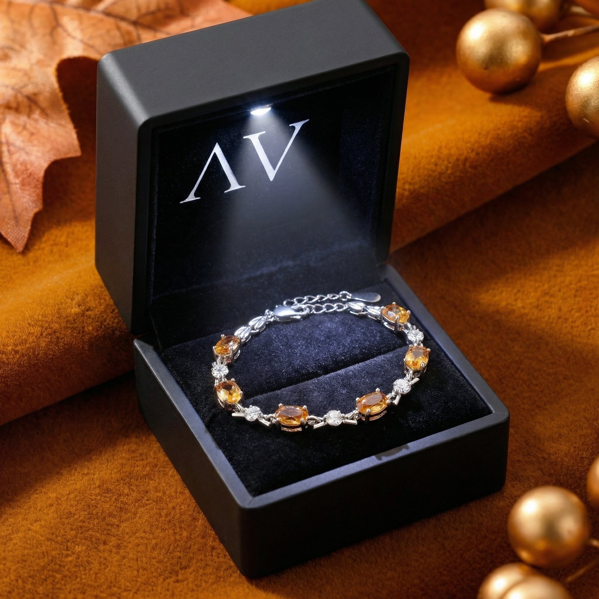 Sterling silver simulated topaz station bracelet inside a black LED-lit jewelry presentation box.