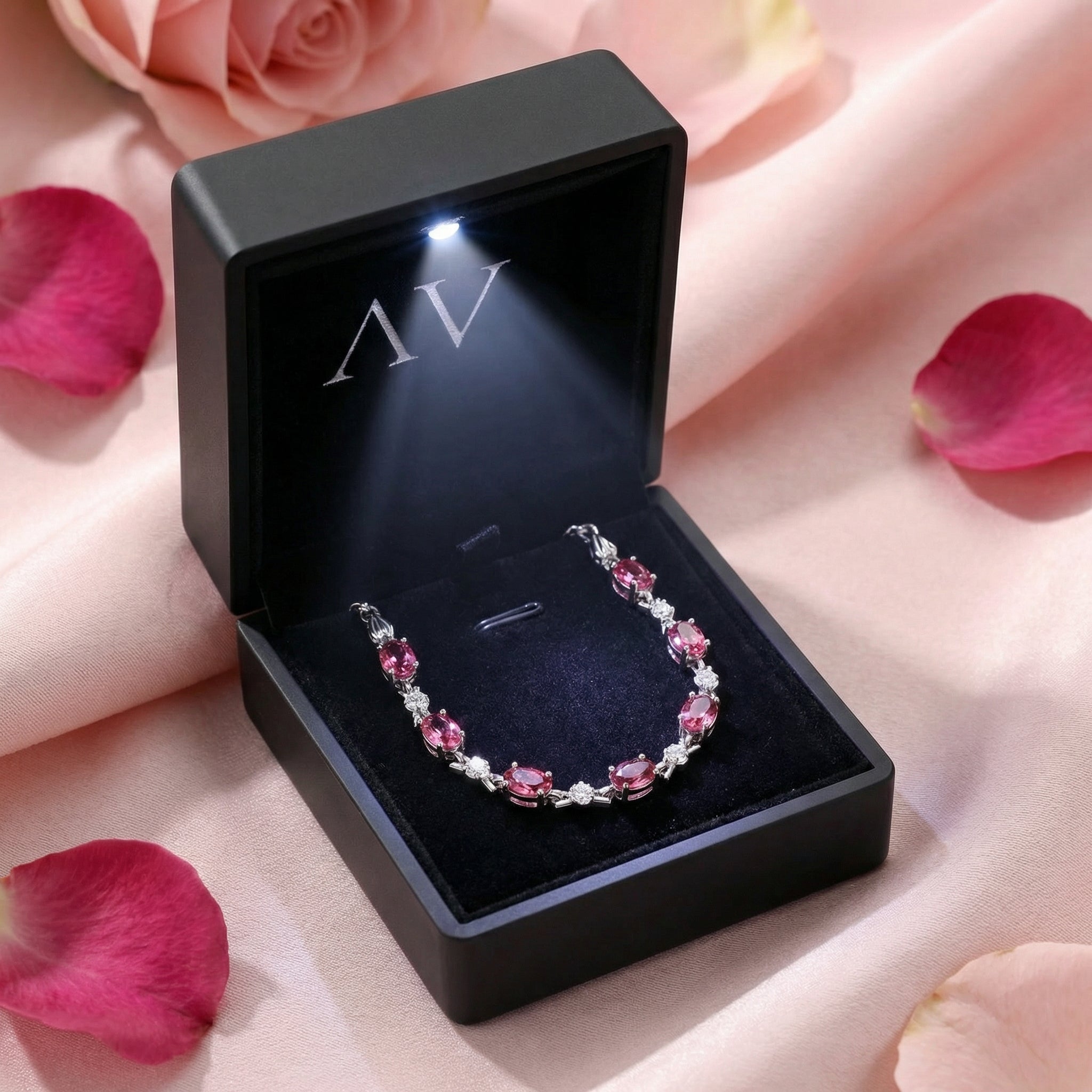 Oval simulated pink tourmaline sterling silver bracelet in a black LED-lighted jewelry gift box.