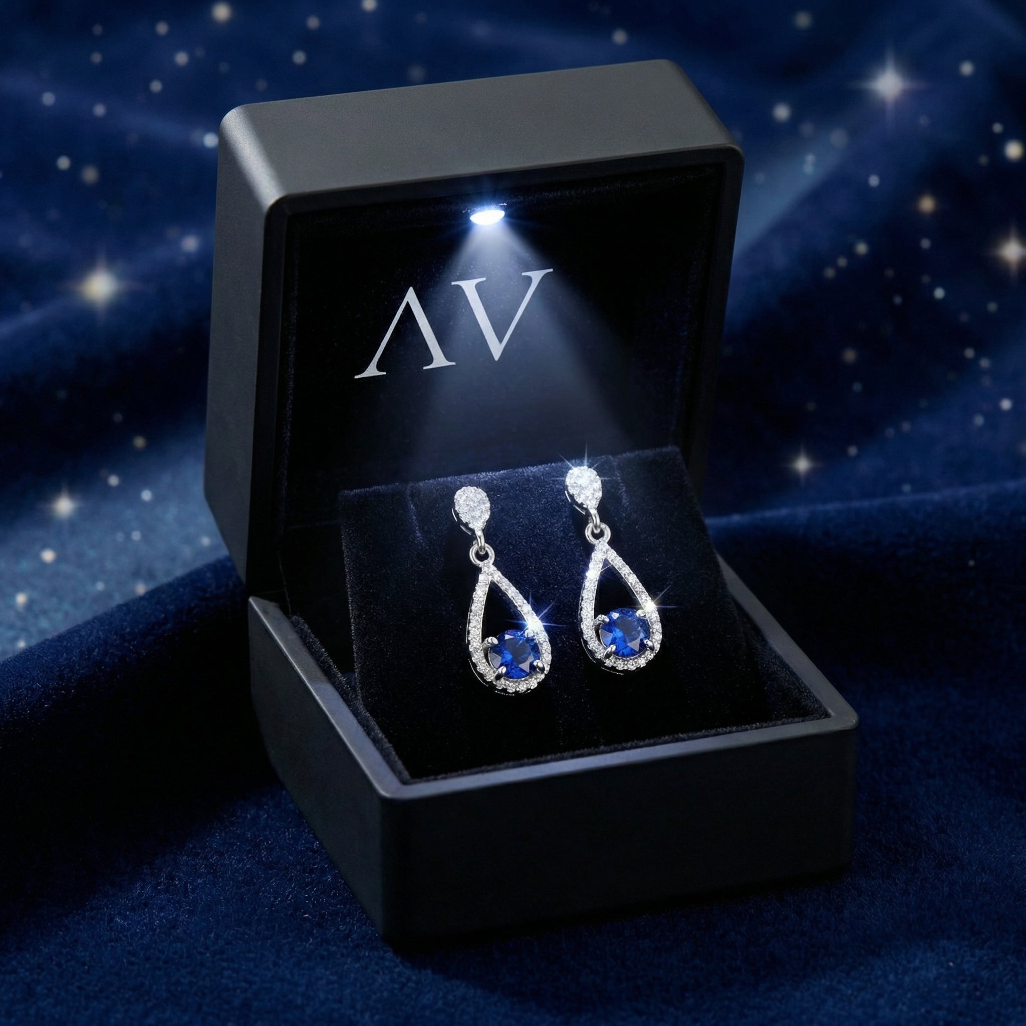 Sterling silver simulated sapphire teardrop earrings presented in a black LED-lit jewelry gift box.