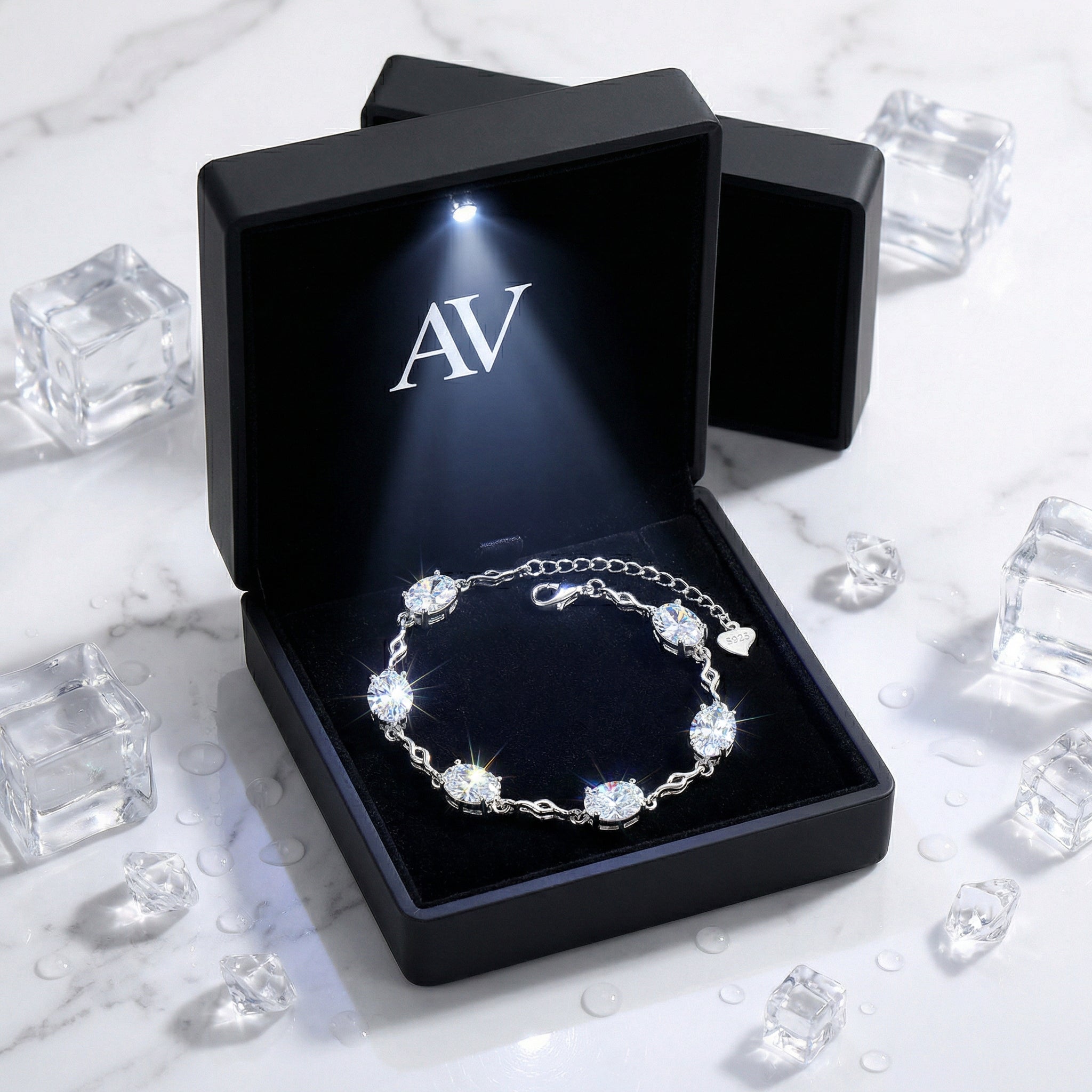 Sterling silver station bracelet with oval zirconia stones inside a black LED-lighted gift box.