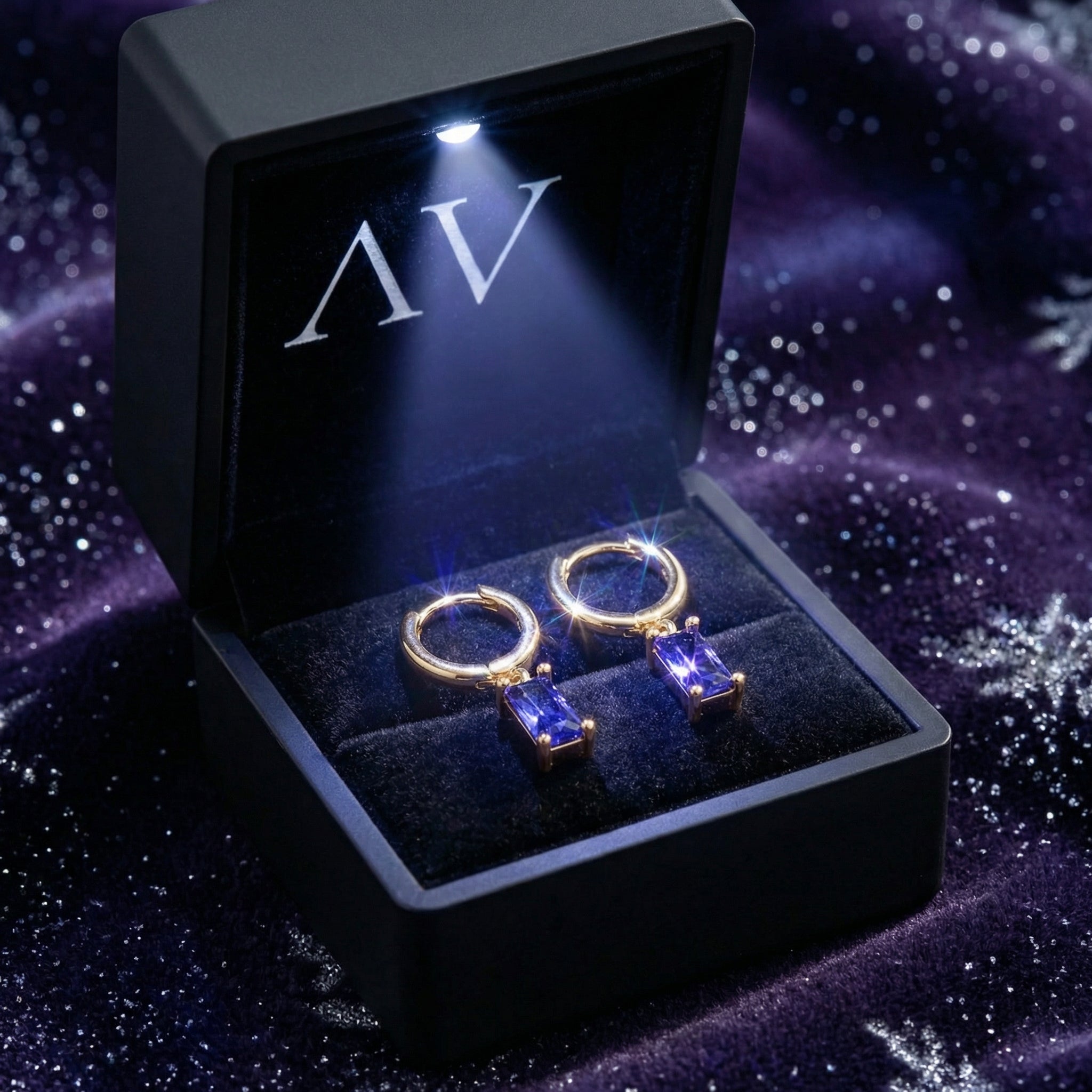 The Valerique 18K gold vermeil simulated tanzanite earrings inside a premium black LED-lit jewelry box.