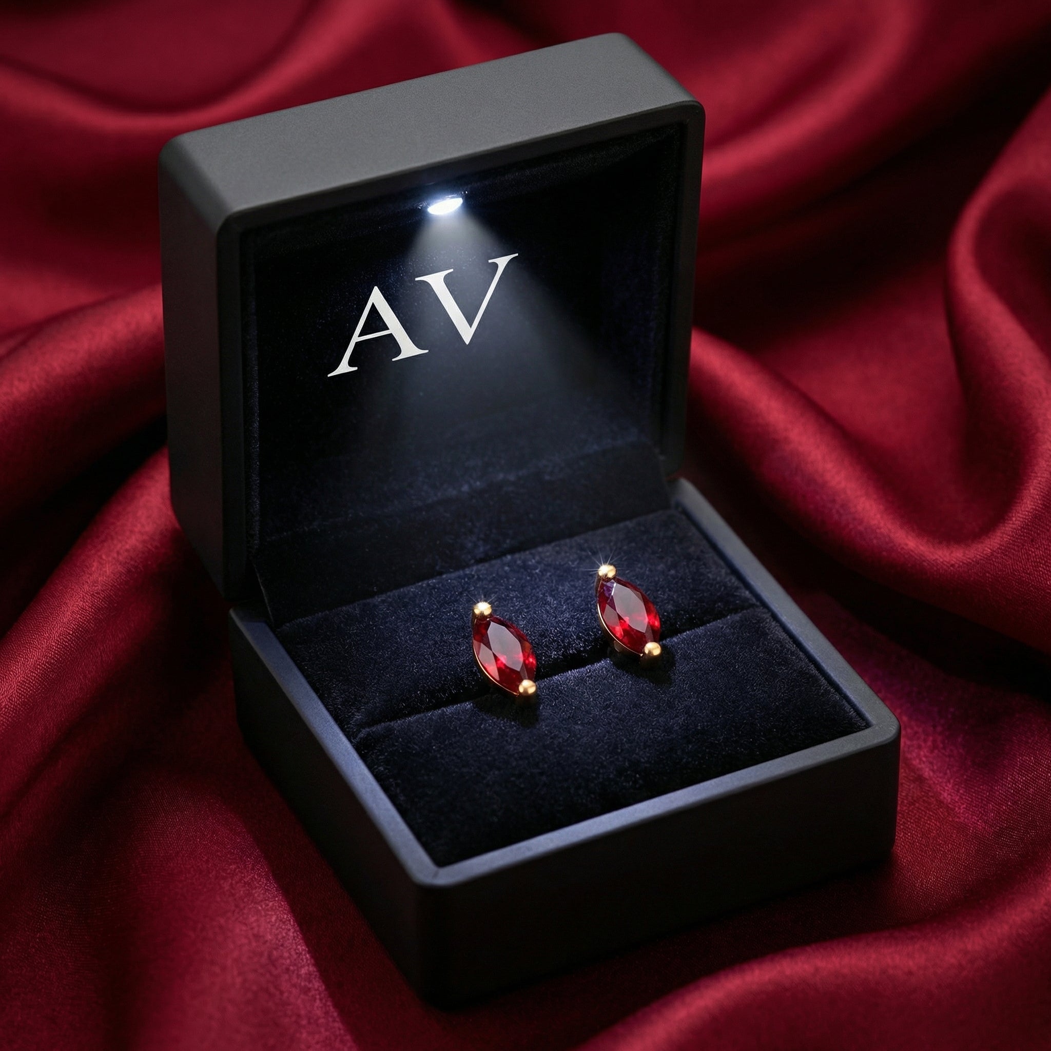 Marquise cut simulated ruby earrings in 18K gold vermeil inside a lighted black jewelry gift box.