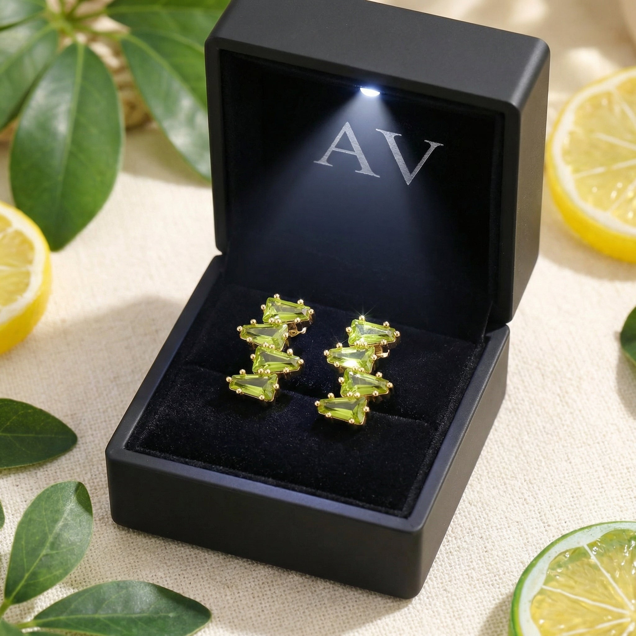 Zephyraea Vine peridot earrings in 18K gold vermeil inside a black lighted gift box with AV branding.