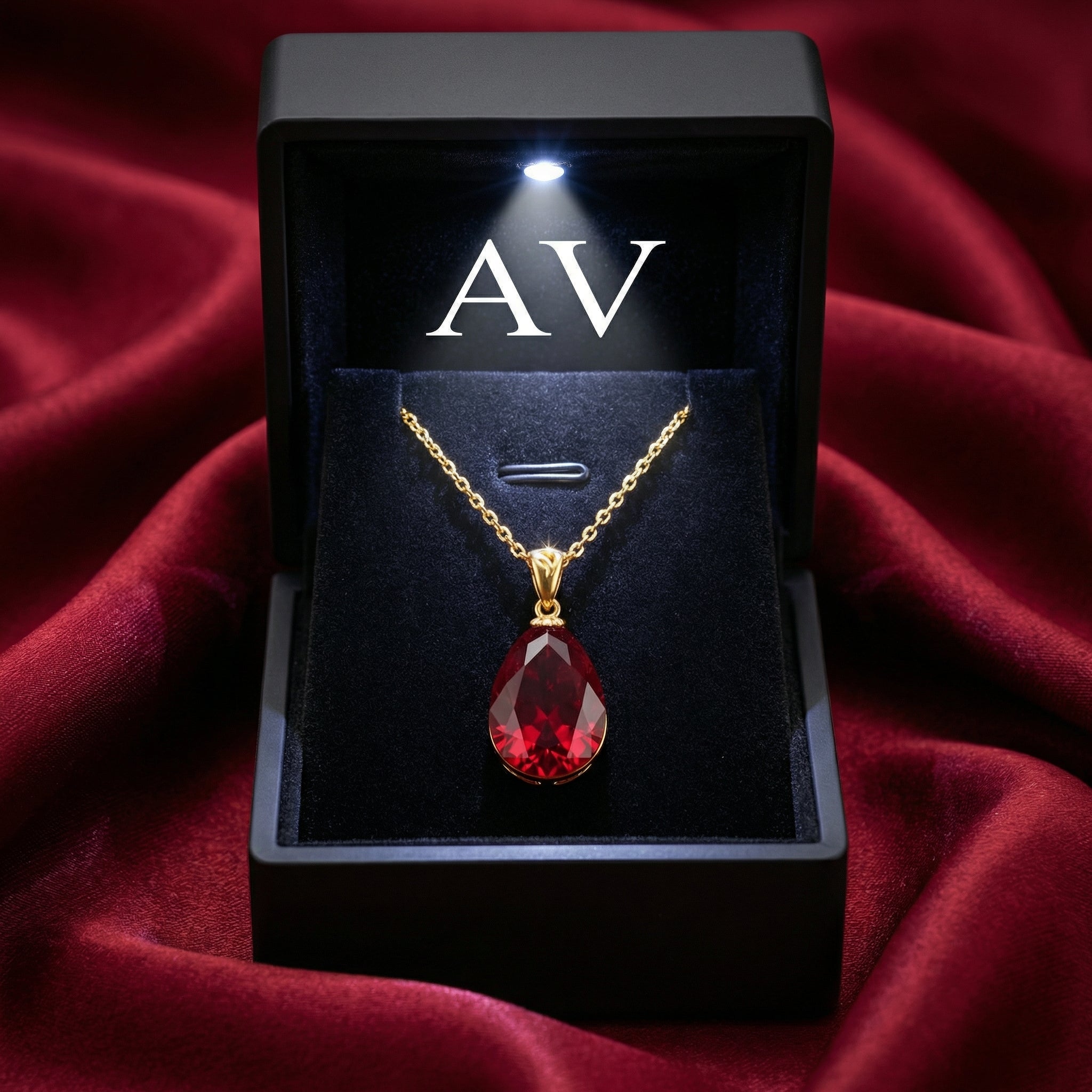 Pear cut simulated ruby necklace in 18K gold vermeil presented in a lighted black jewelry gift box.