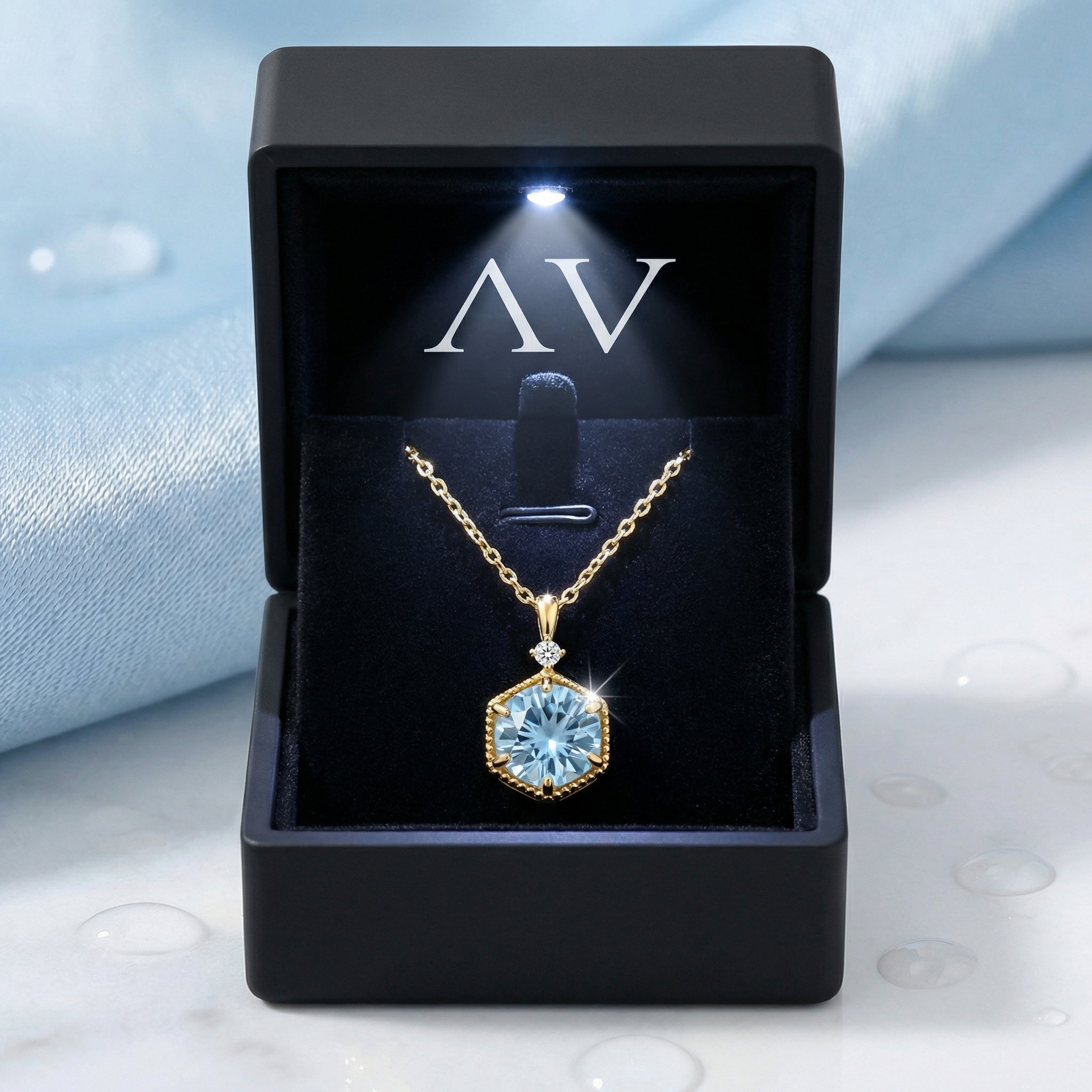 Callia Hex 18K gold vermeil aquamarine necklace displayed in a black lighted jewelry box.