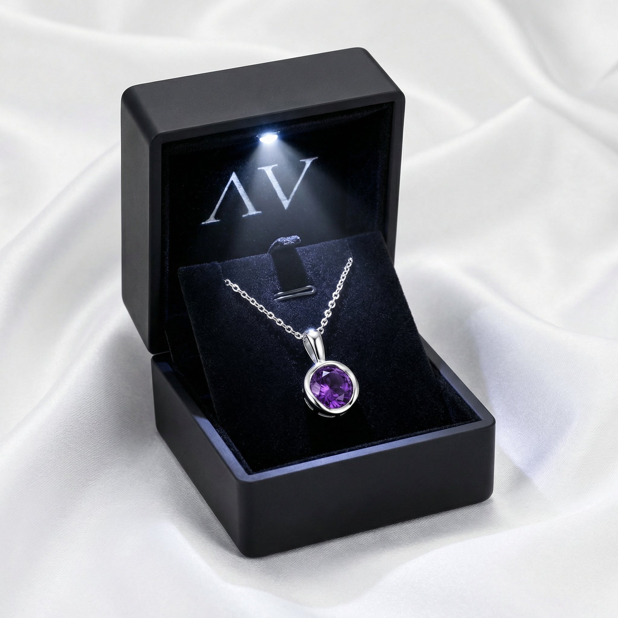 Round cut deep royal purple simulated amethyst necklace in a black LED-lit gift box on white silk.
