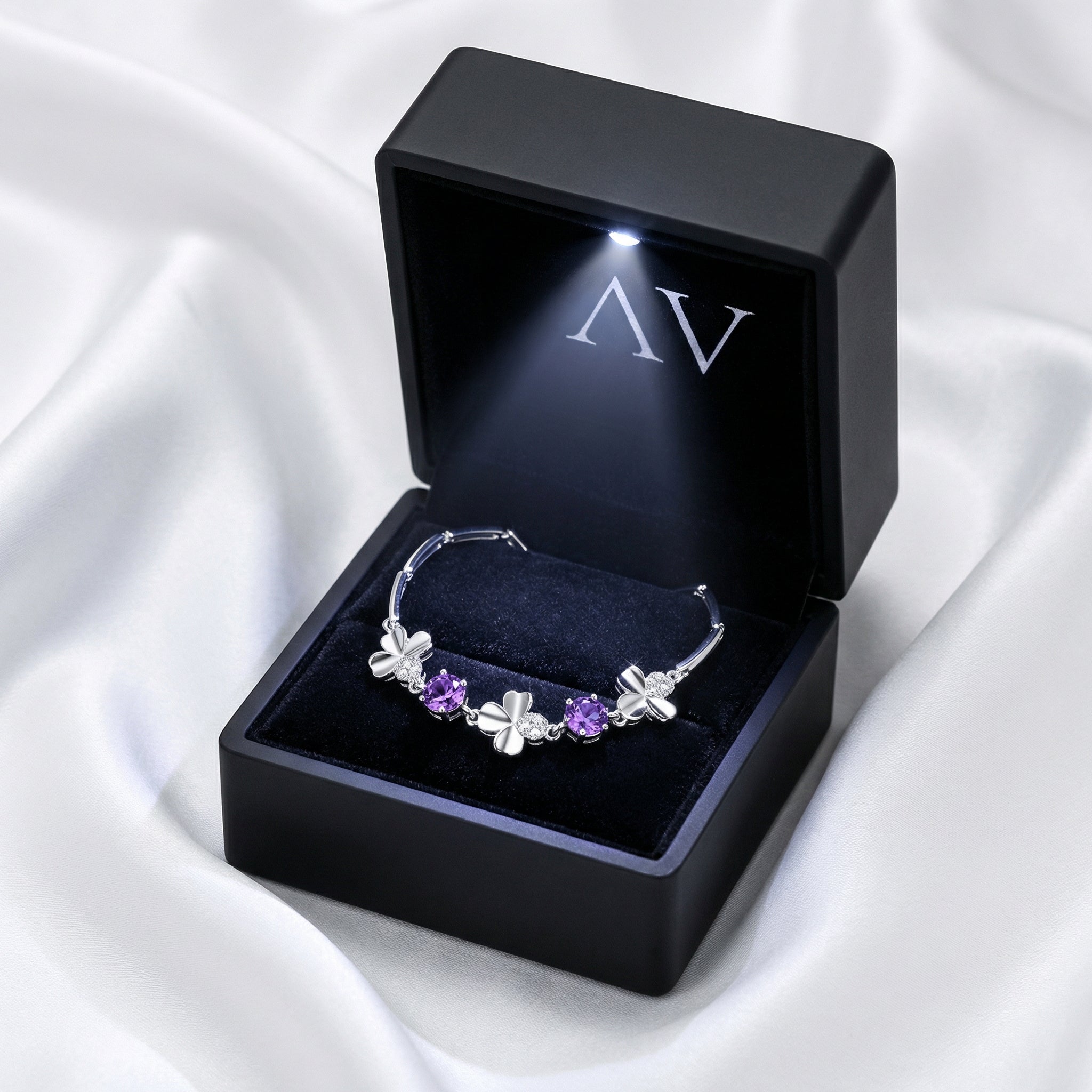 Sterling silver simulated amethyst clover bracelet inside a premium black LED-lit jewelry gift box.