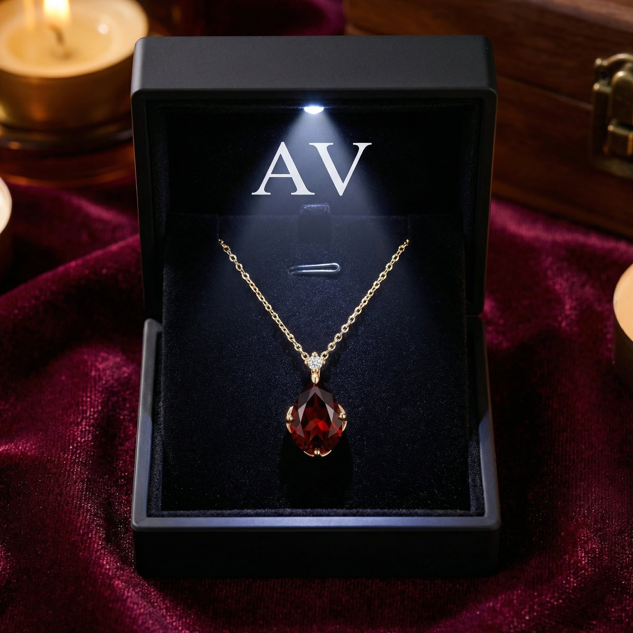Front view of the pear-shaped simulated garnet necklace in 18K gold vermeil inside a black LED-lit gift box.