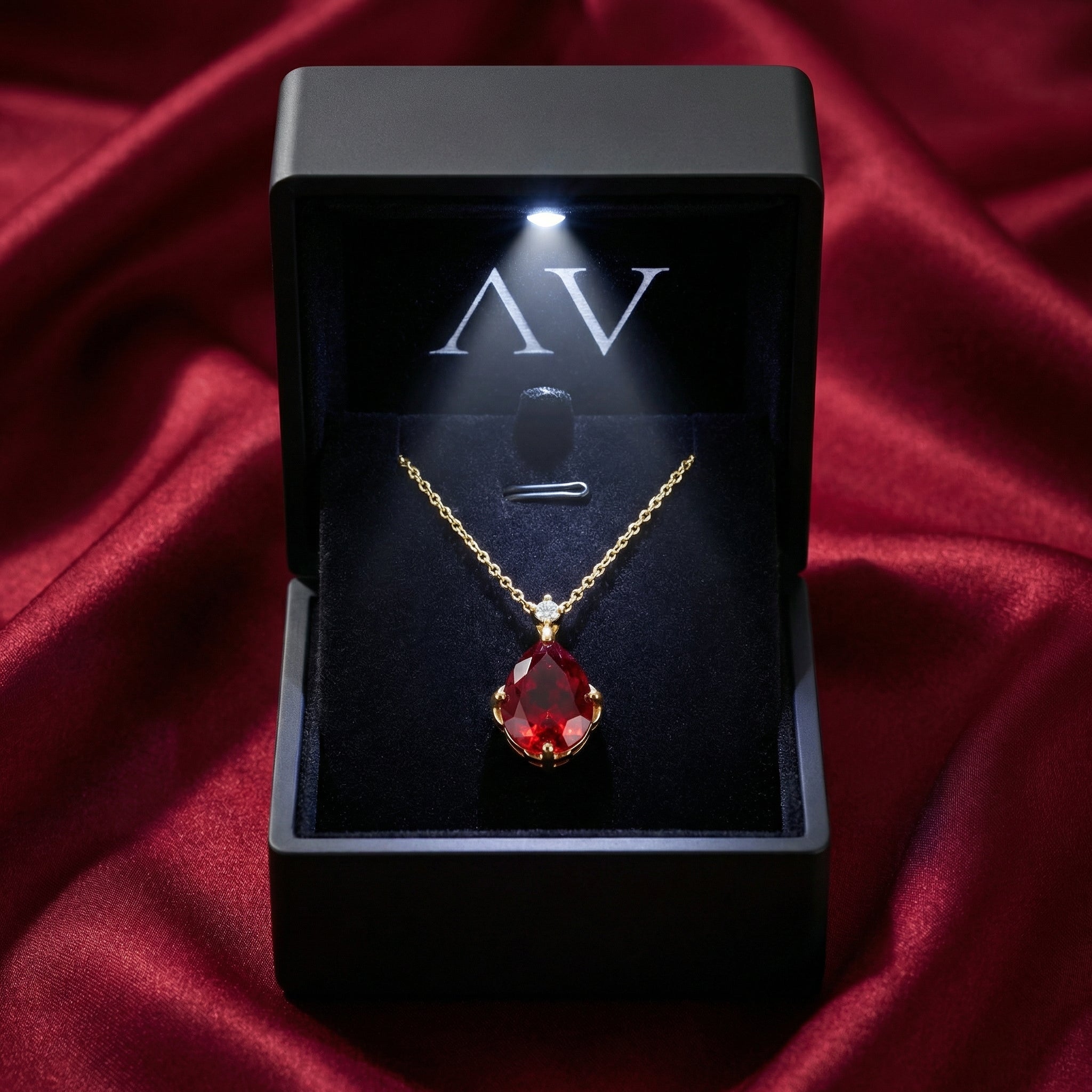 Teardrop simulated ruby necklace presented in a black lighted gift box on red silk.