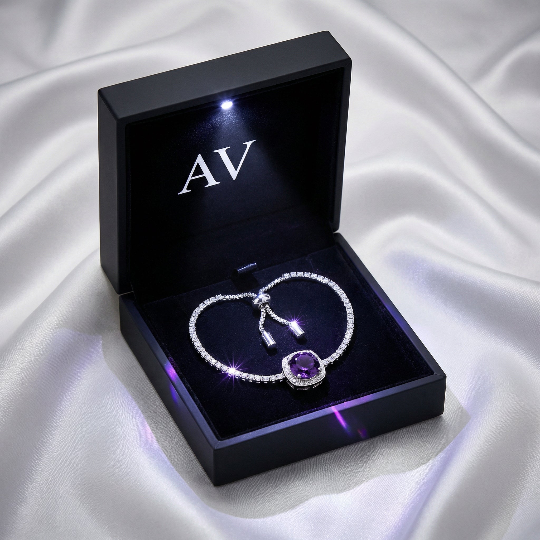 Sterling silver purple amethyst halo bracelet presented in a black LED-lit jewelry gift box on white silk.
