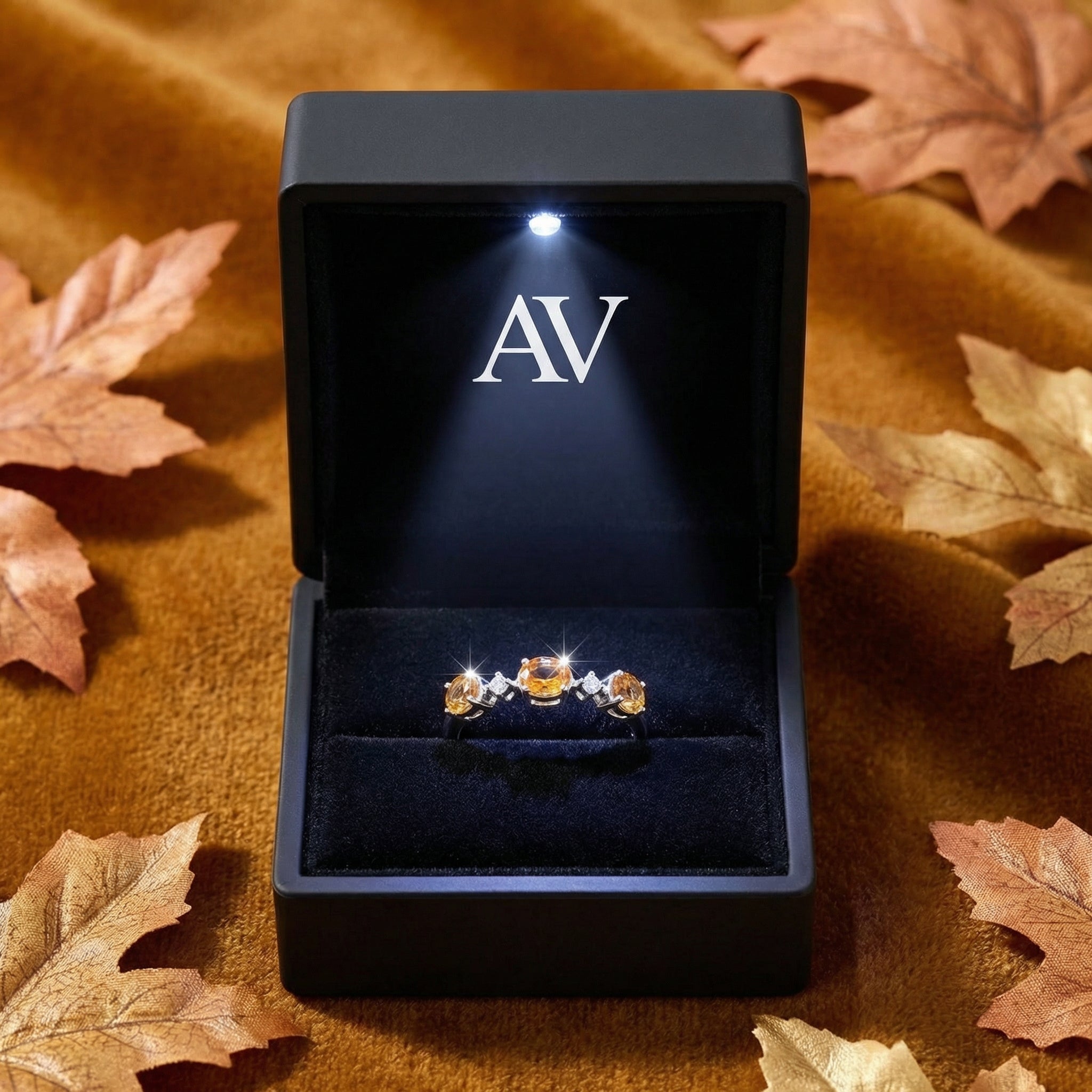 Evalise sterling silver bypass ring with simulated topaz in a black lighted jewelry box with AV branding.