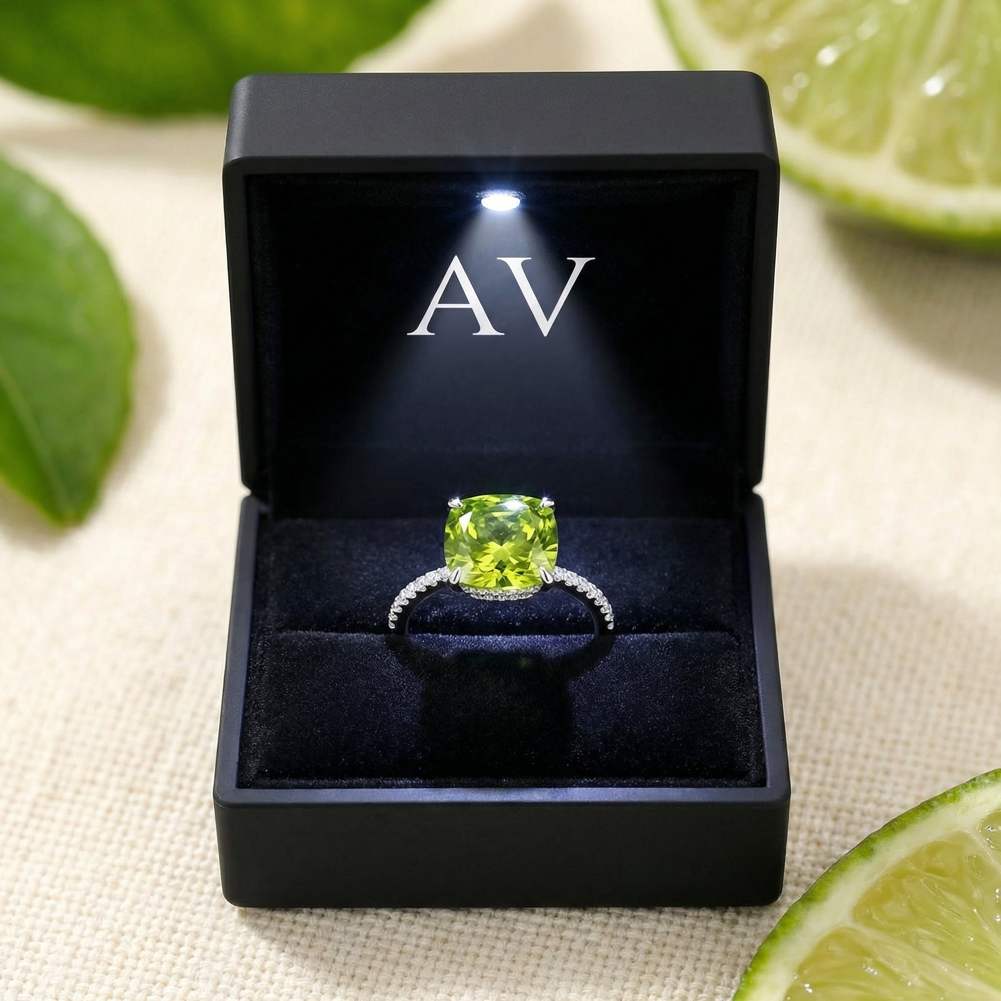 Cushion-cut simulated peridot ring in S925 sterling silver inside a black lighted AV jewelry gift box.