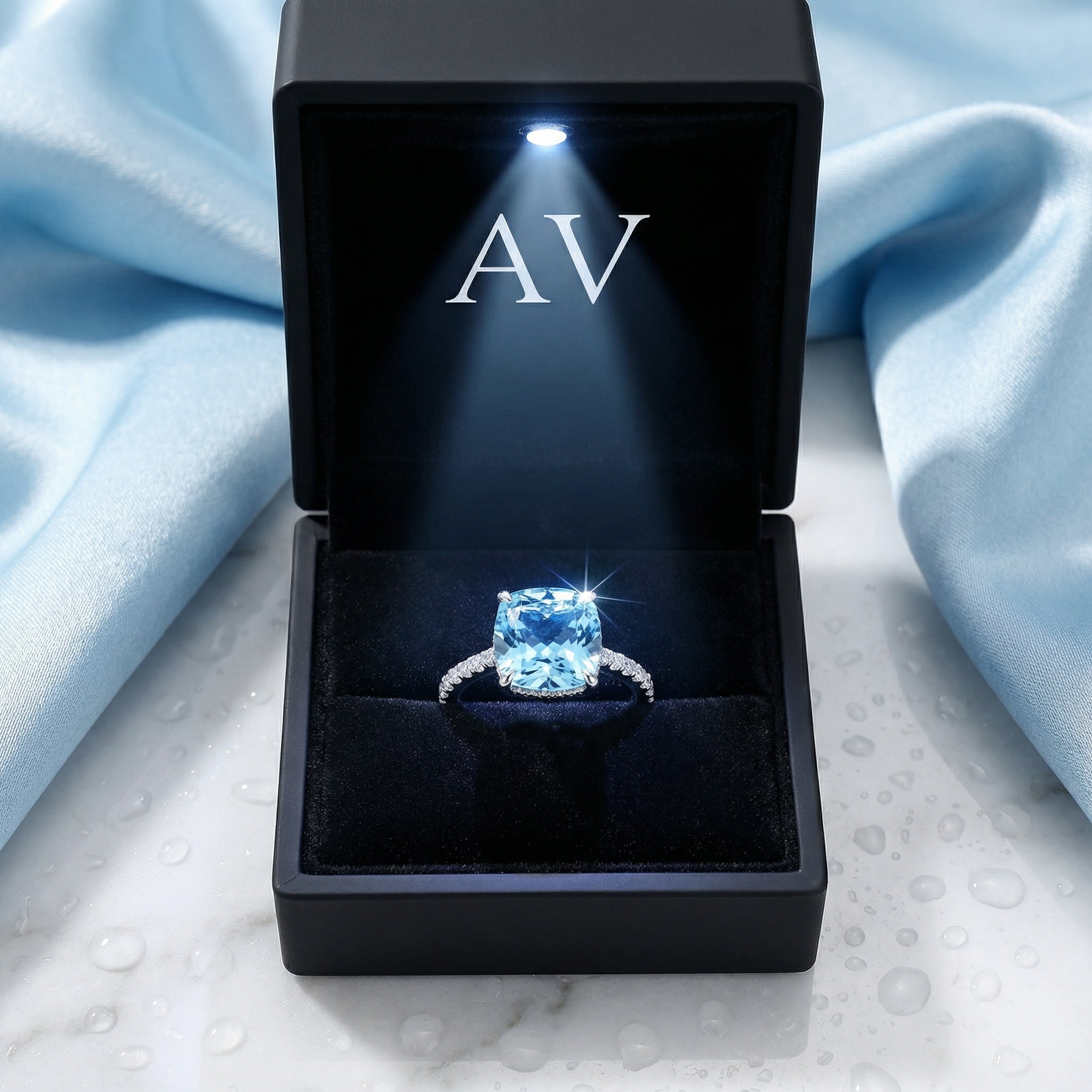 Lysia sterling silver halo ring with a cushion cut simulated aquamarine in a lighted black jewelry gift box.