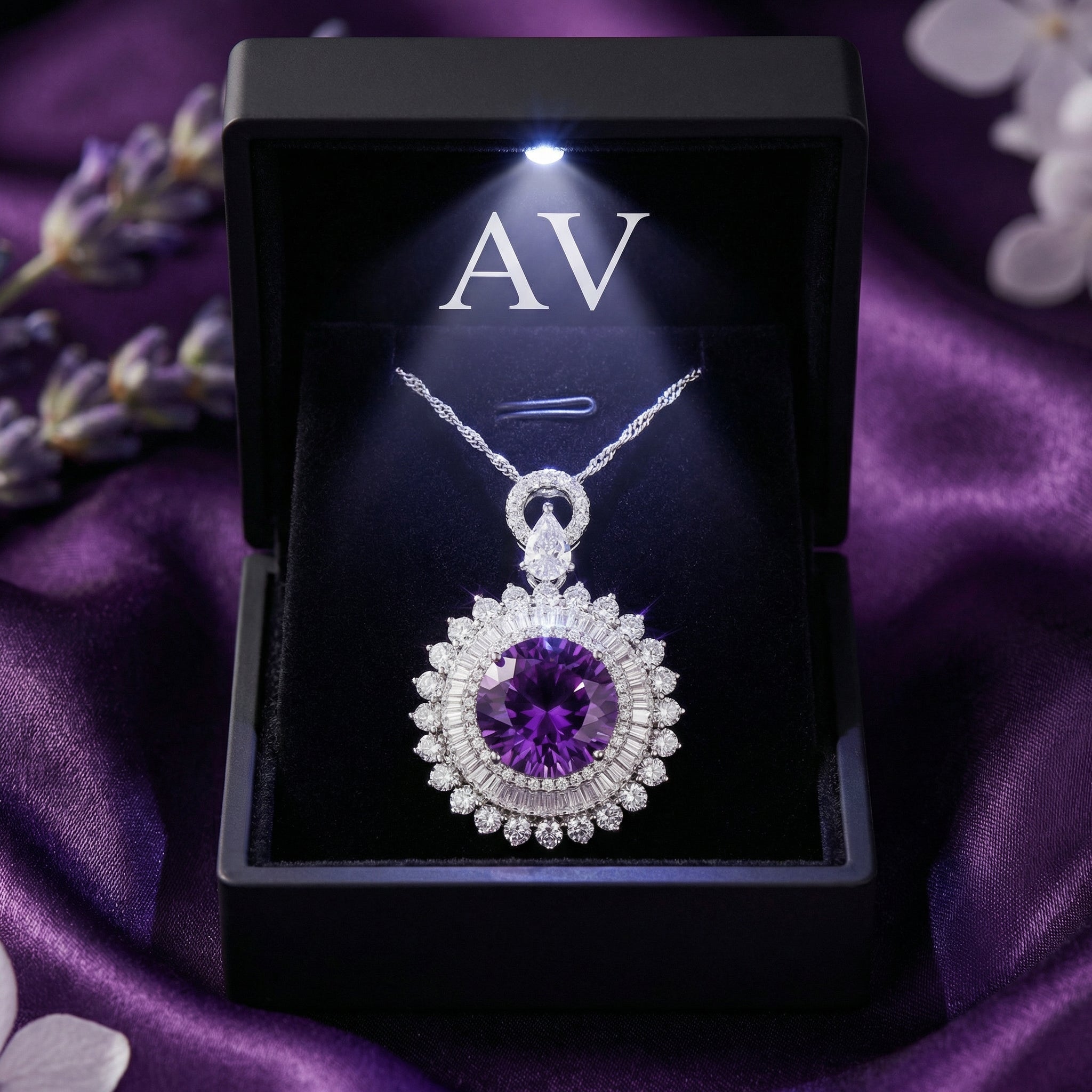 Sterling silver round cut amethyst pendant displayed in a black LED-lit jewelry gift box on purple silk.