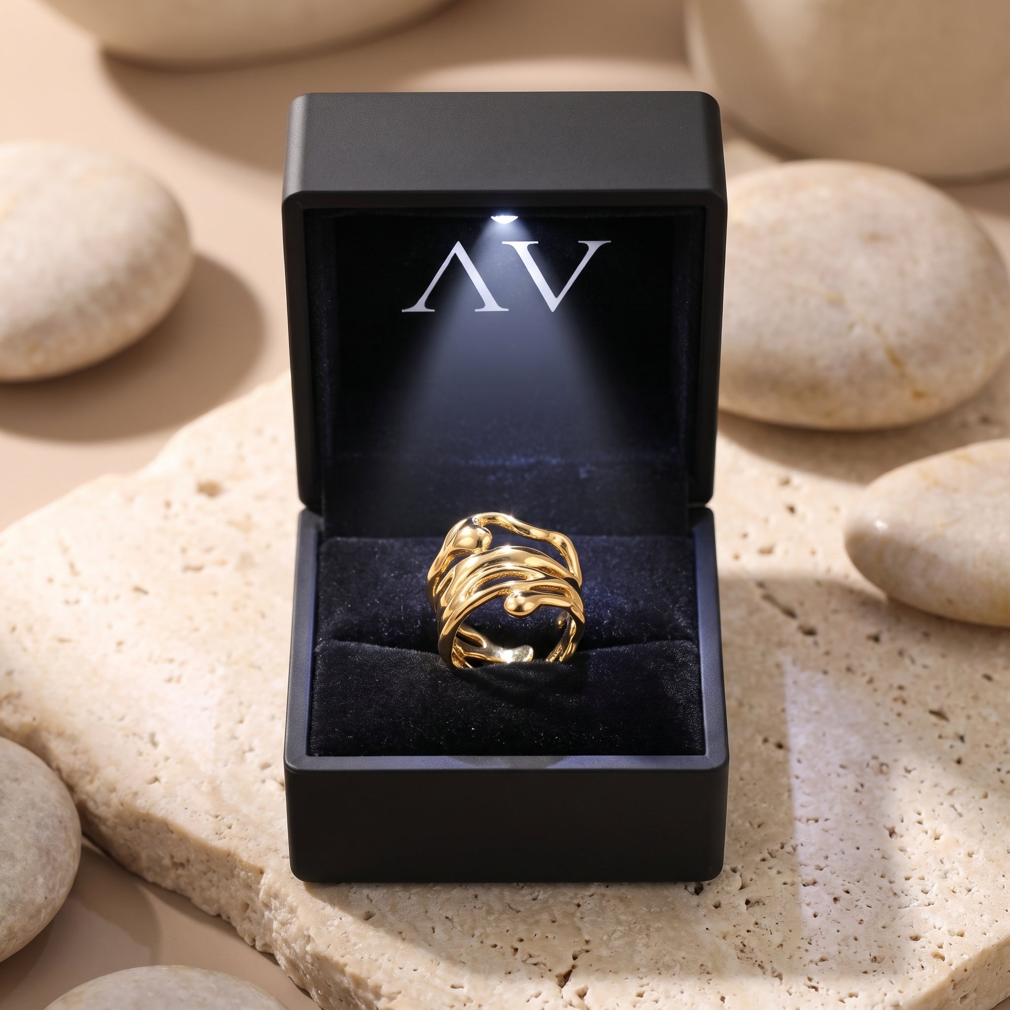 The Marinella Ring, a solid gold ring, presented inside a black LED-lit jewelry box.