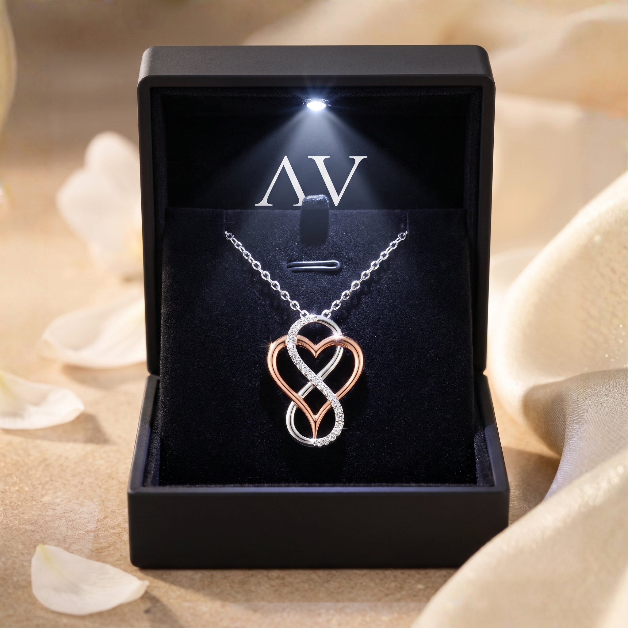 Infinity heart moissanite necklace in solid gold displayed in a black LED-lit gift box.